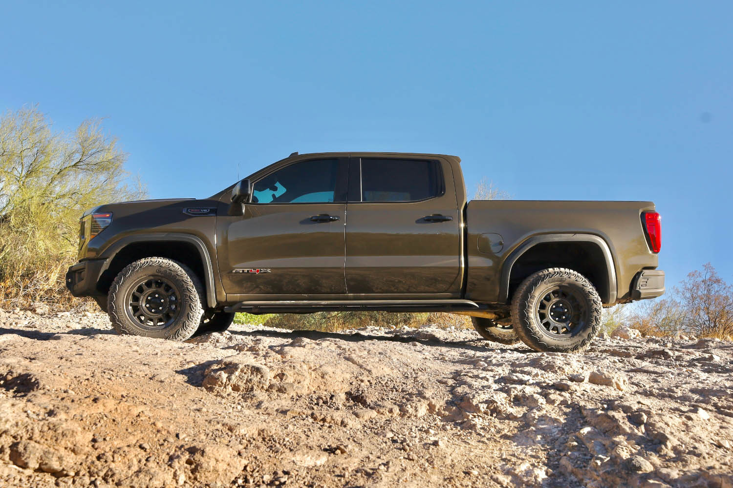 Side view of a brown 2023 GMC Sierra 1500 AT4X in the dessert