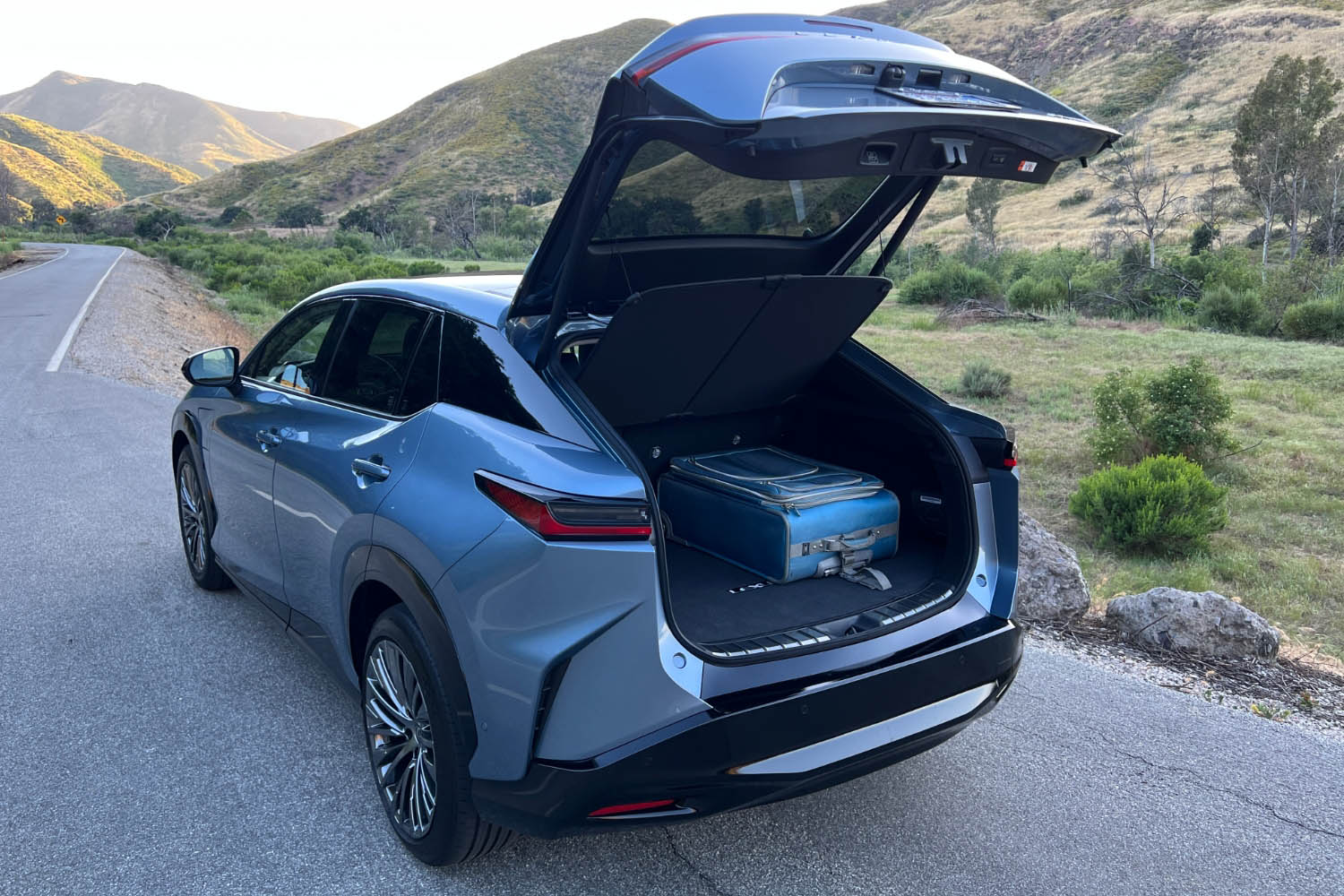 The cargo area of a blue 2023 Lexus RZ holding a suitcase