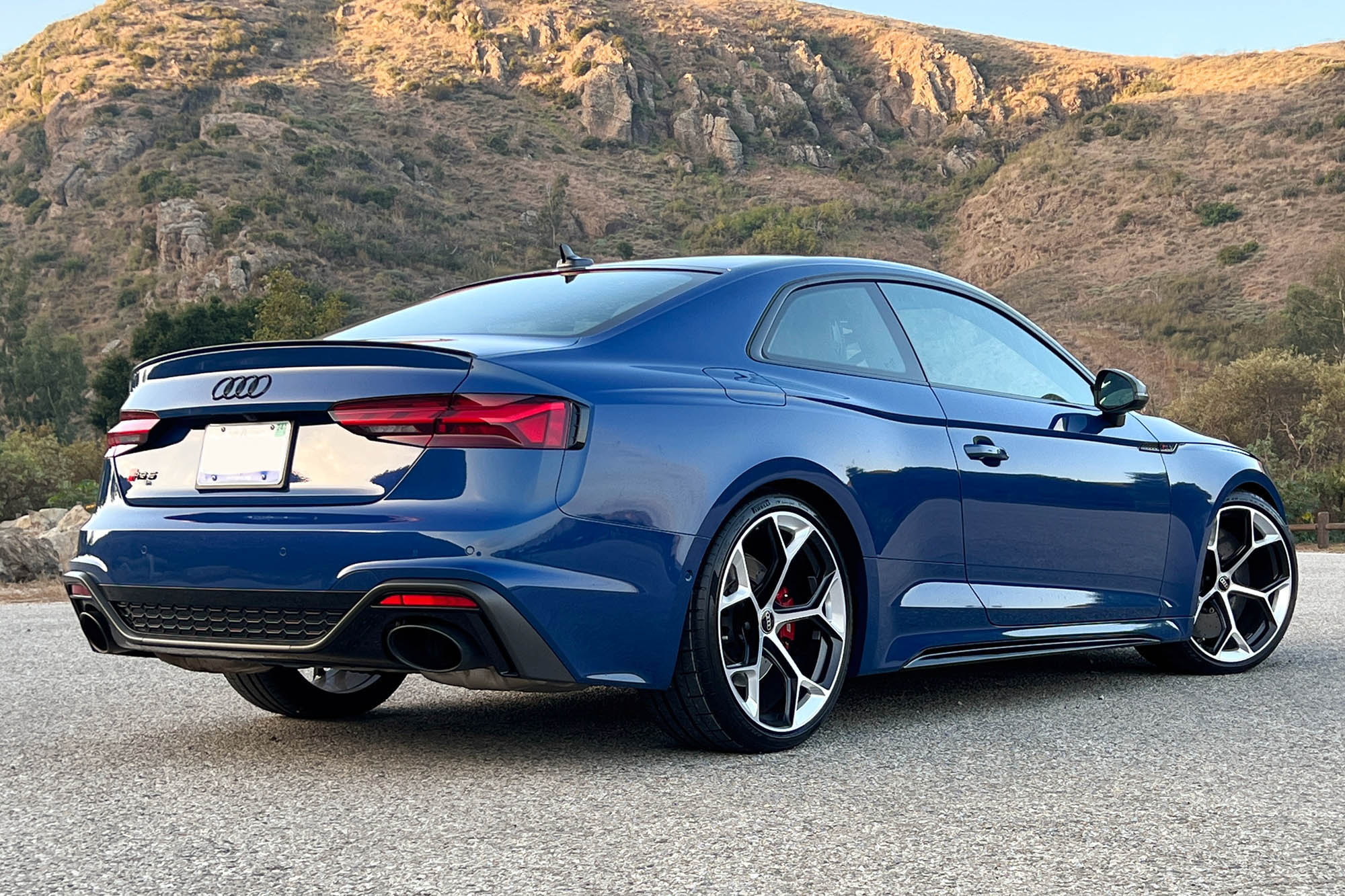 Rear right quarter view of a blue 2023 Audi RS 5