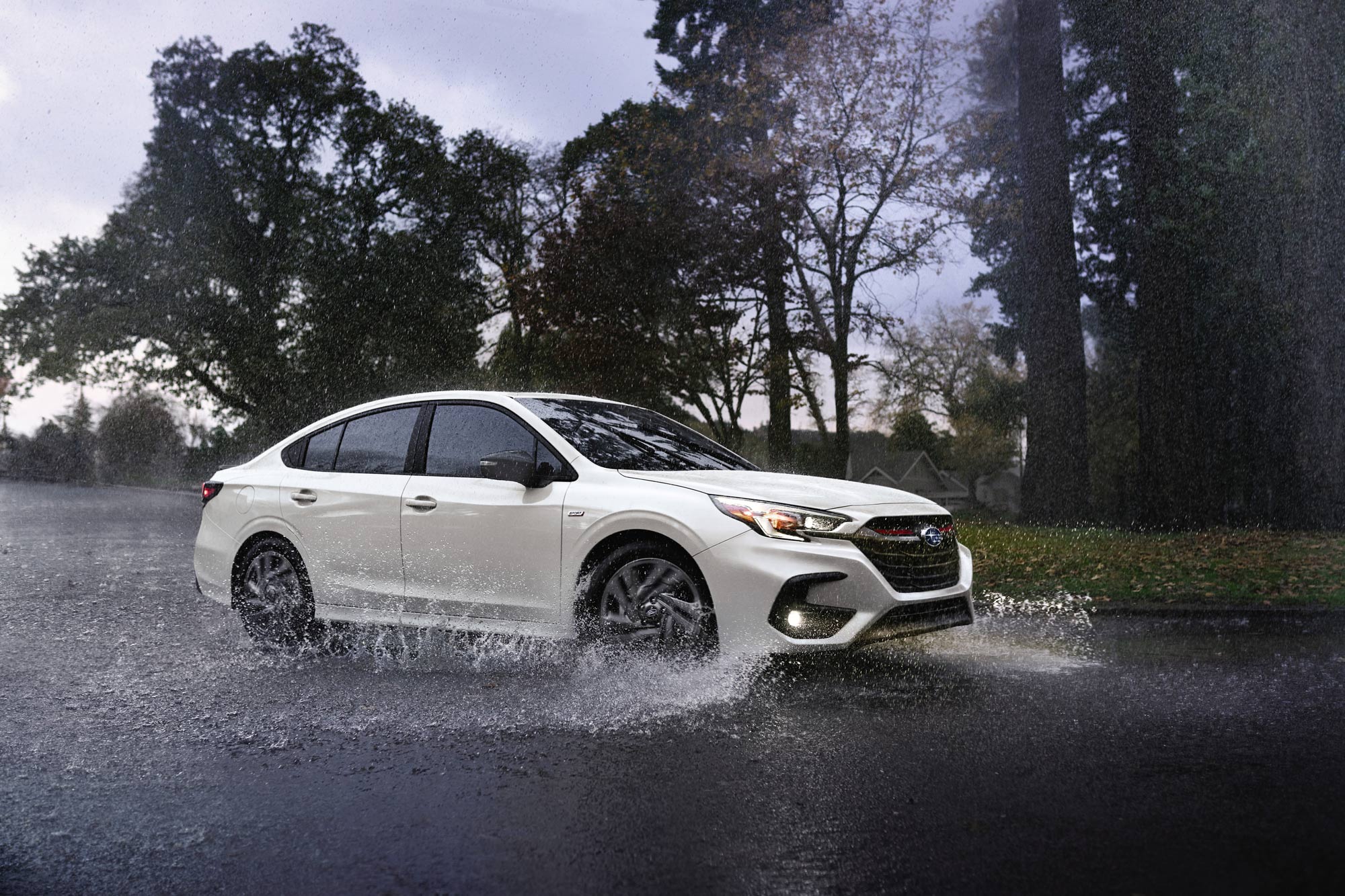 White 2023 Subaru Legacy driving in the rain