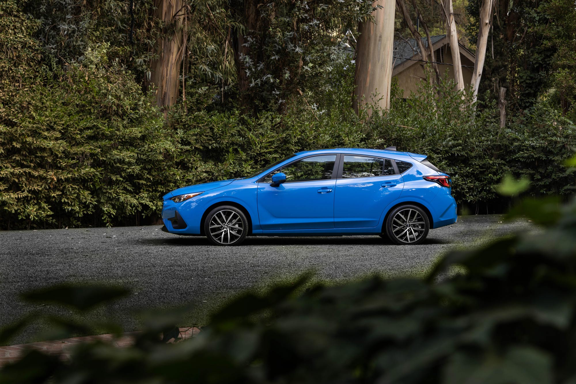 Blue 2024 Subaru Impreza parked in the woods