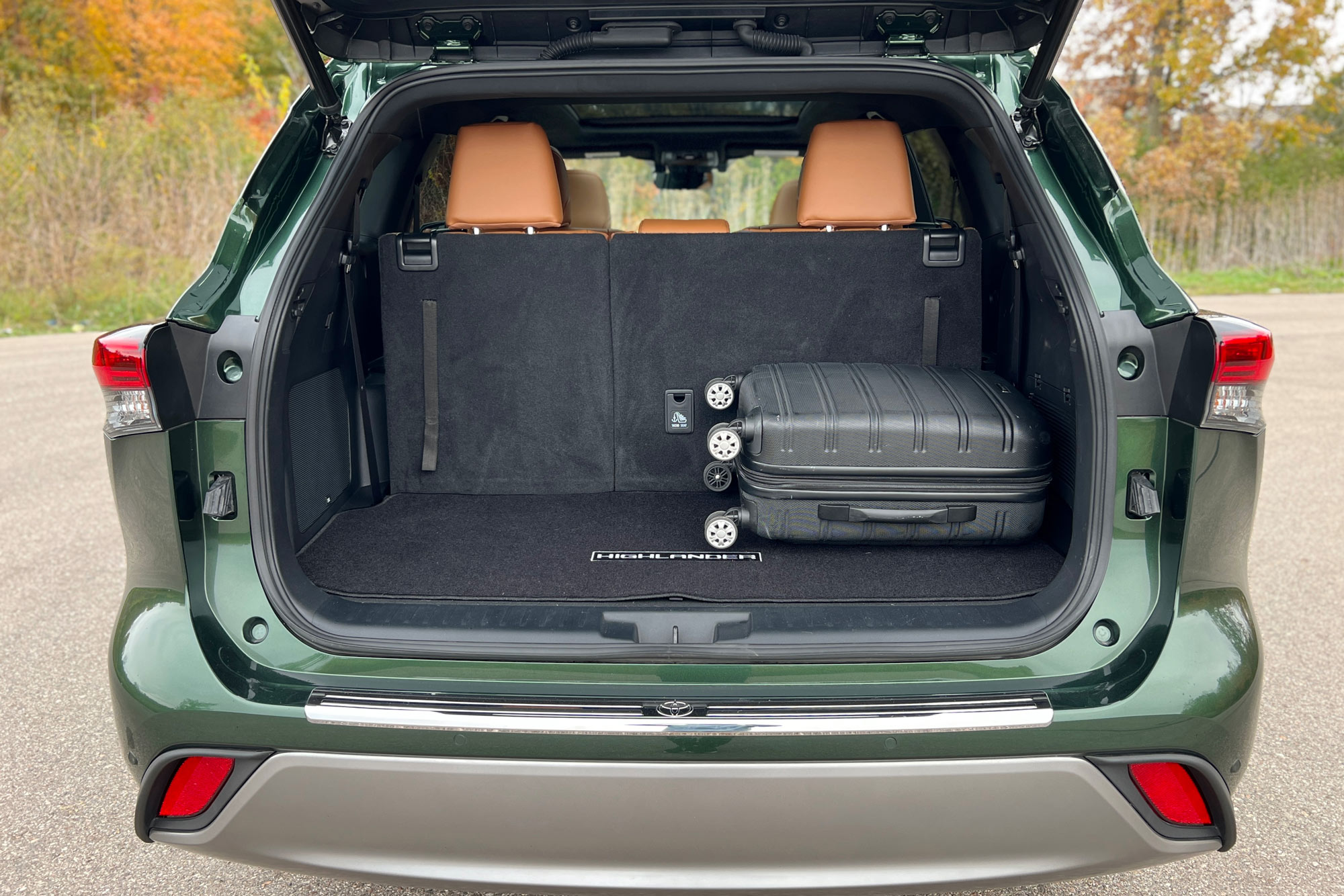 2024 Toyota Highlander cargo area with third row up and luggage stored.