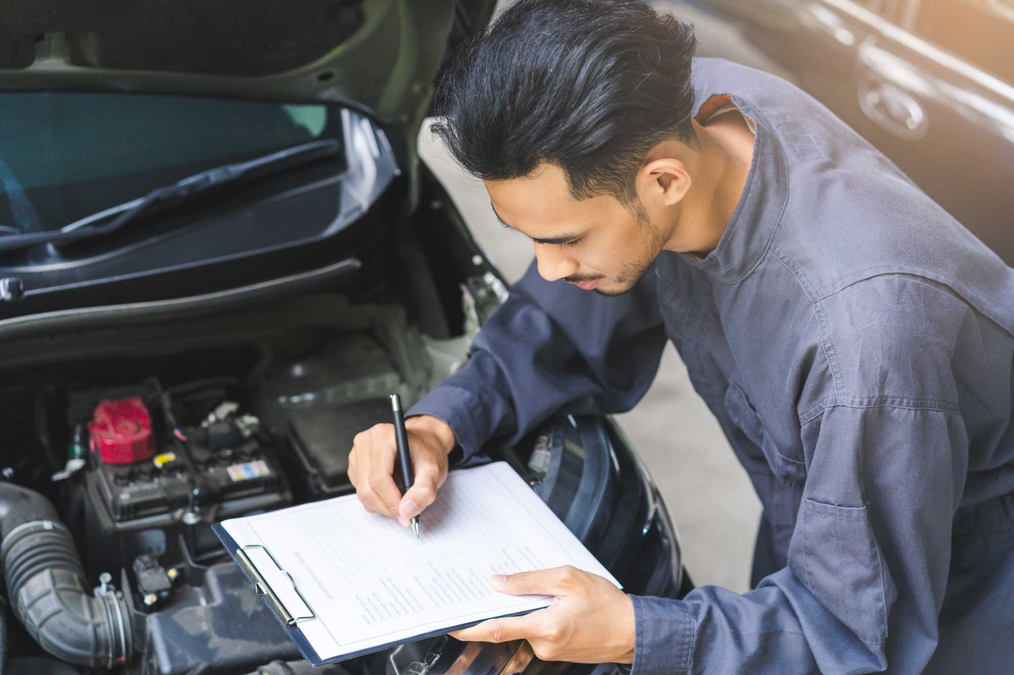 Mechanic filling out paperwork for vehicle