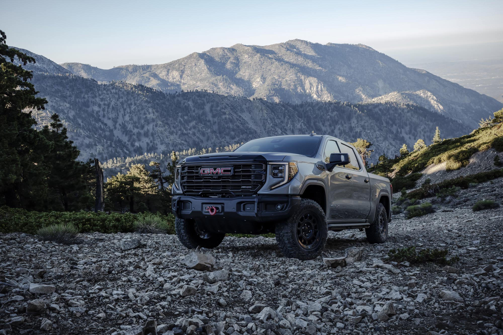 The 2023 GMC Sierra 1500 AT4X AEV Edition driving on a rocky hillside