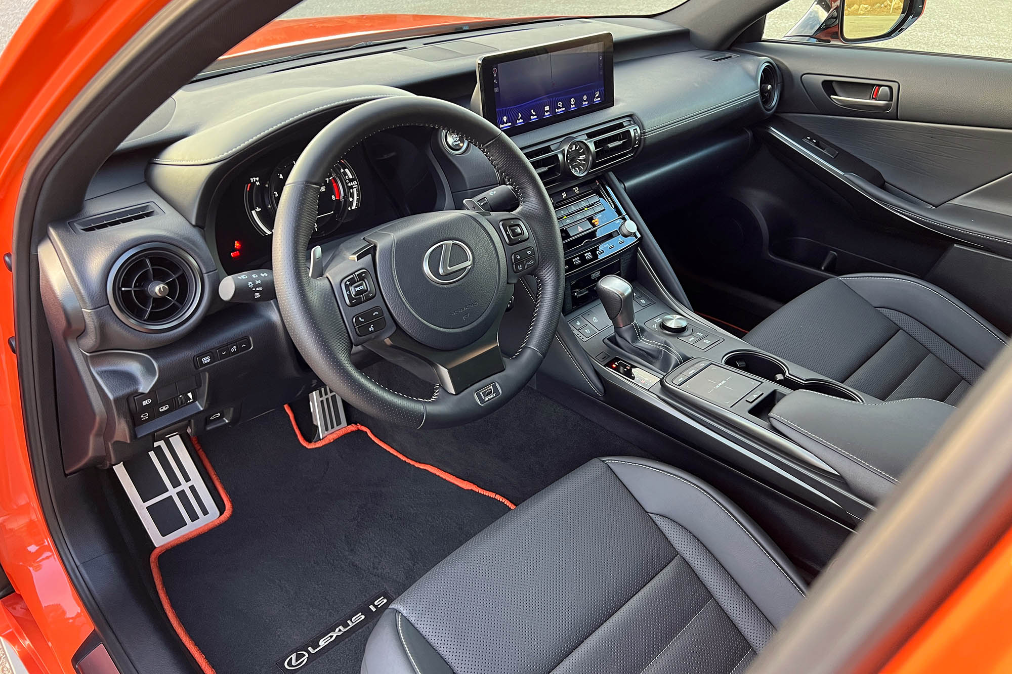 The front seats and dashboard of an orange 2023 Lexus IS 500