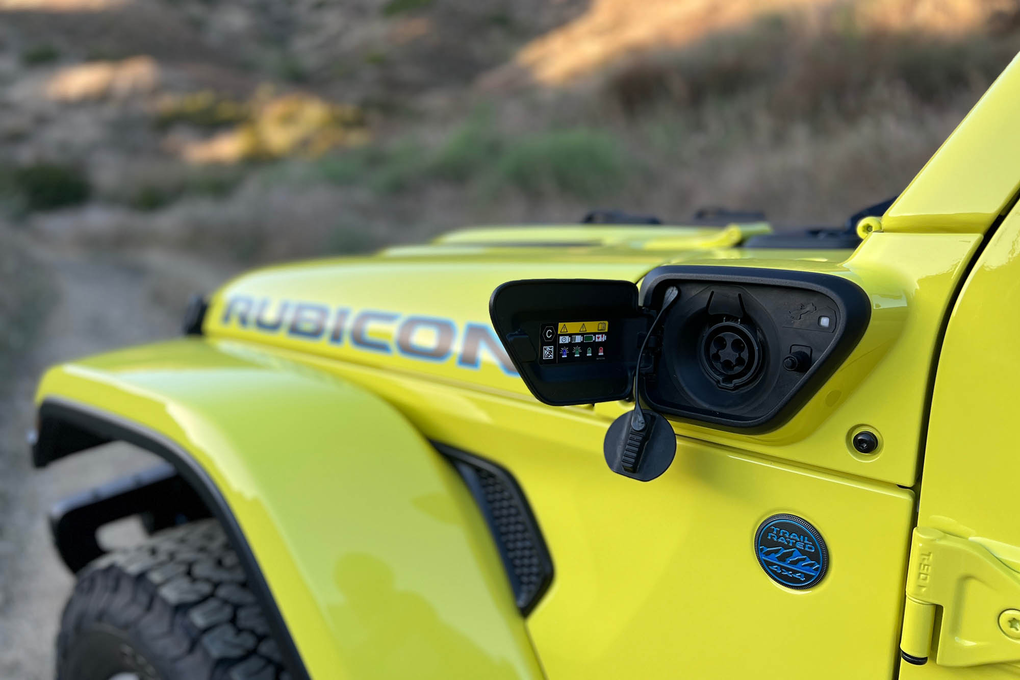 View of the charging port on a yellow 2024 Jeep Wrangler Rubicon 4xe