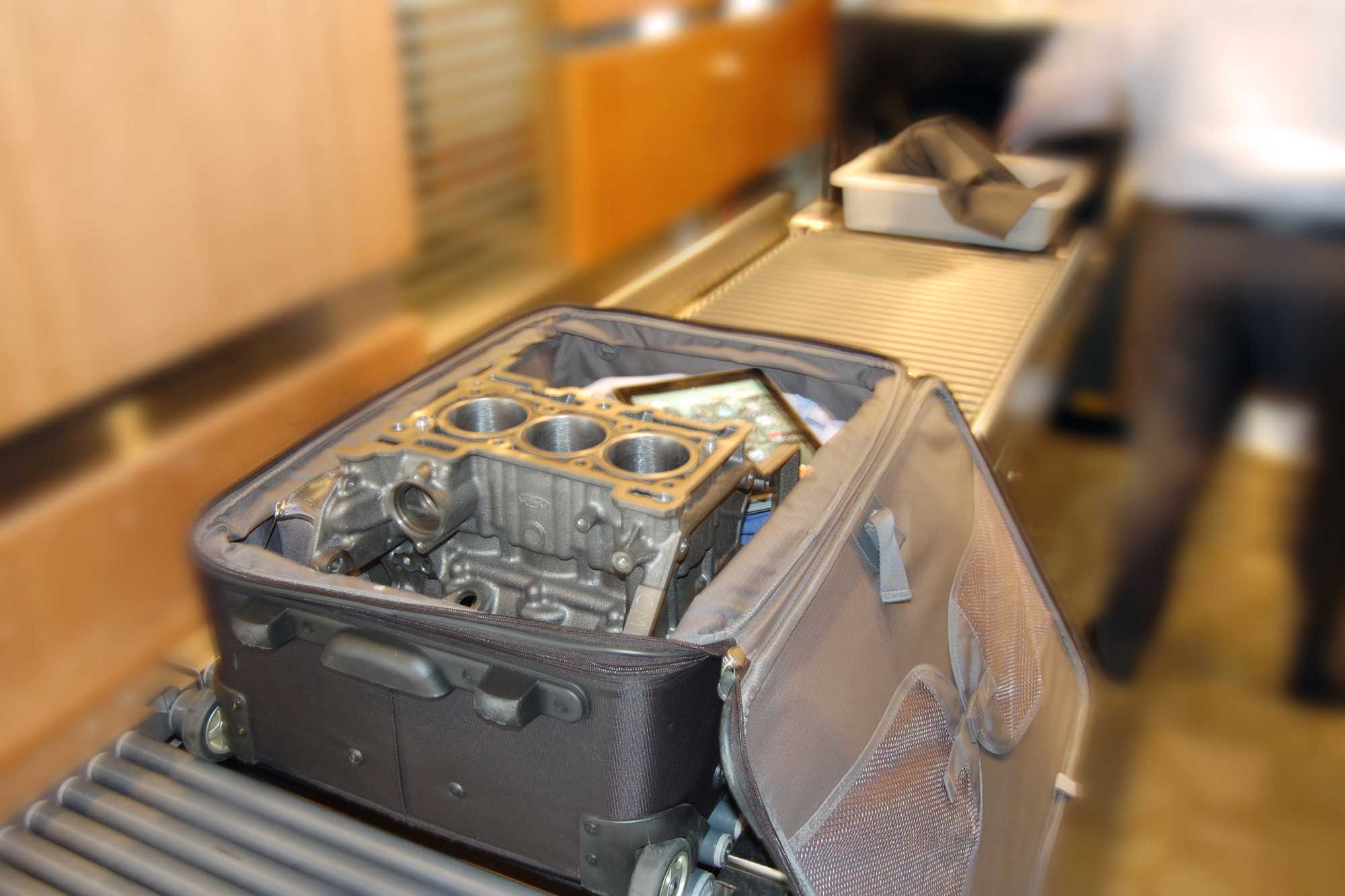 Ford Fiesta engine in suitcase on TSA conveyor belt