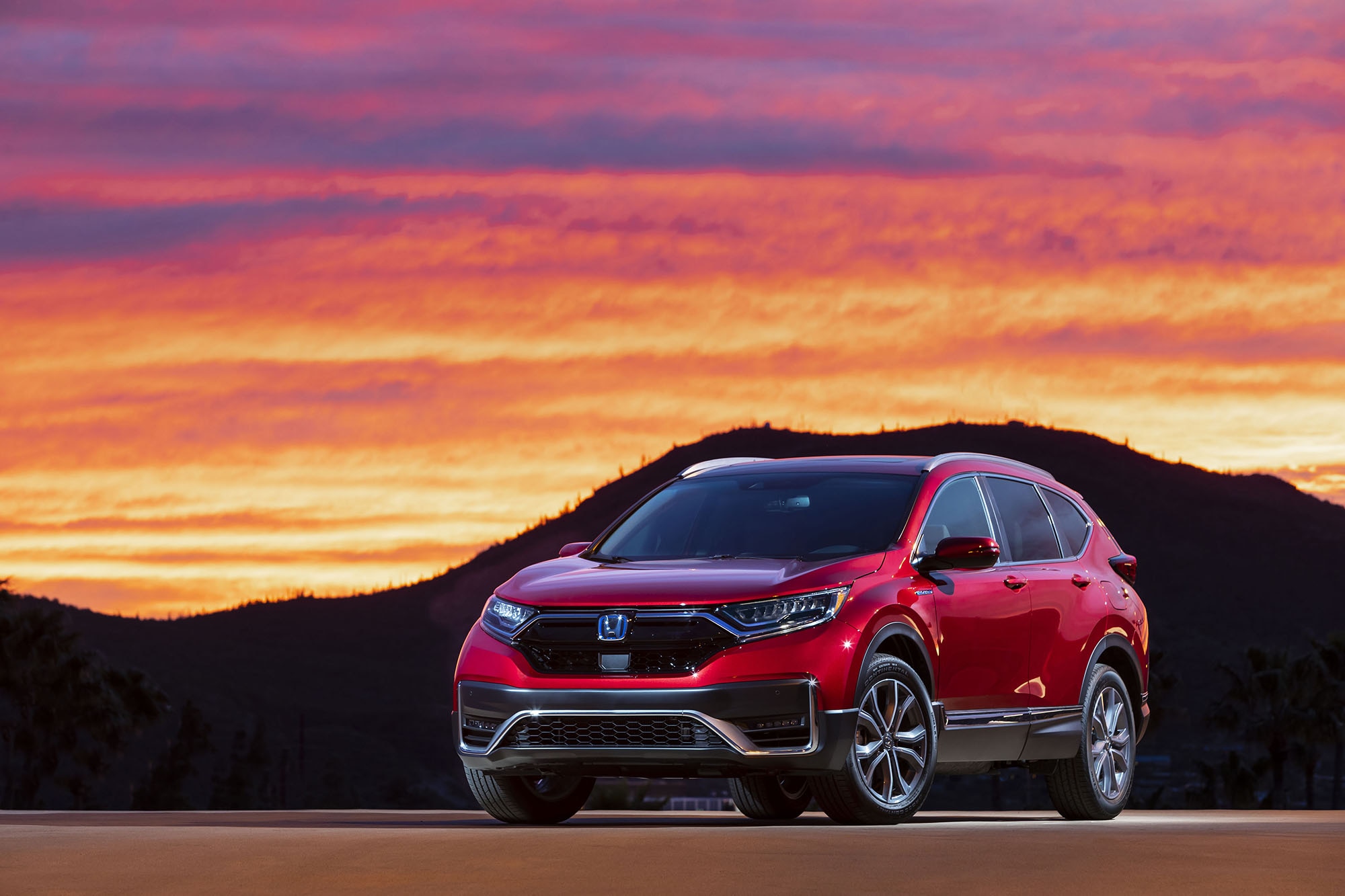 Red 2022 Honda CR-V Hybrid in front of a mountain at sunset