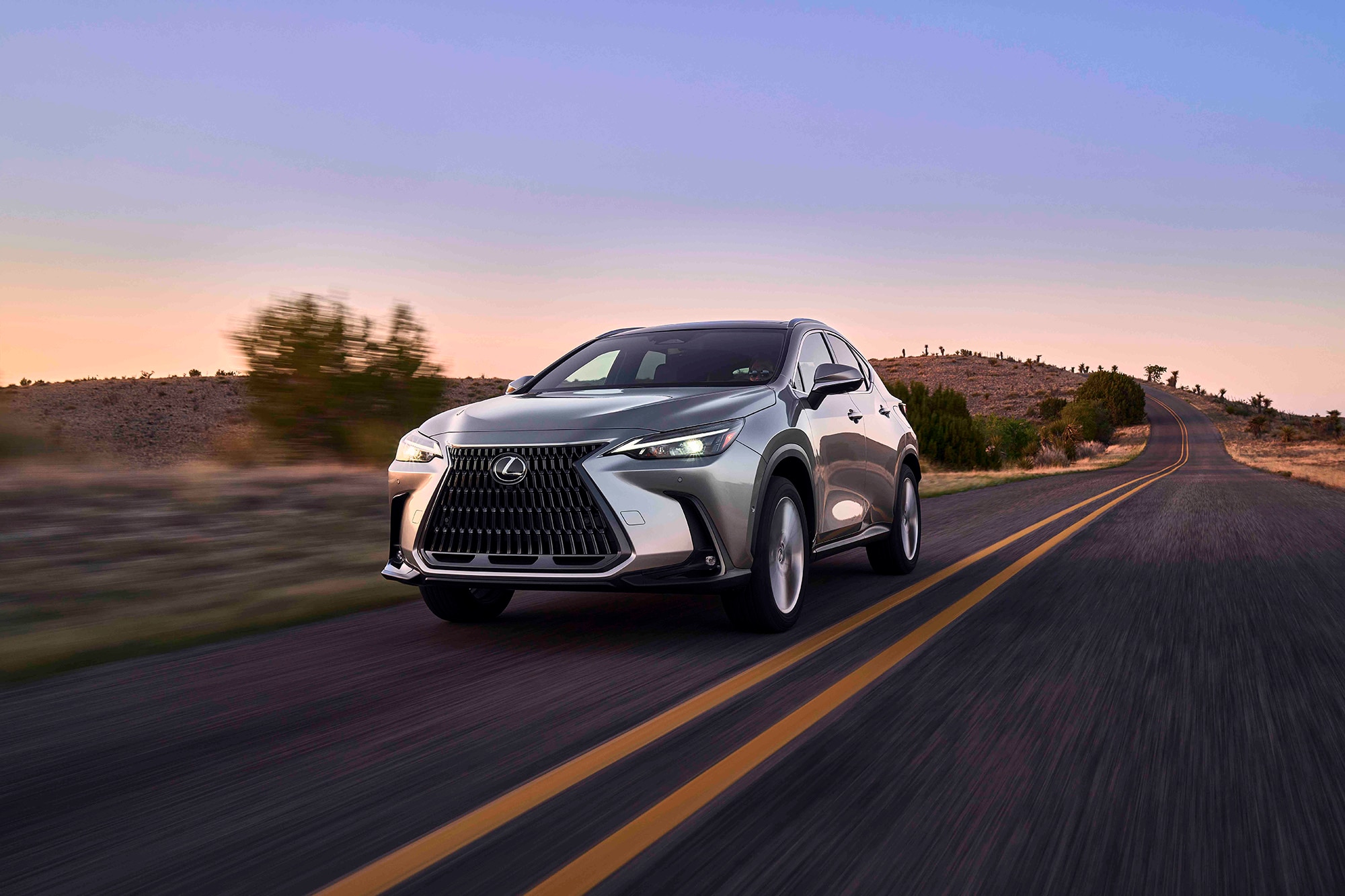 2023 Lexus NX 350h in sliver driving on a rural road