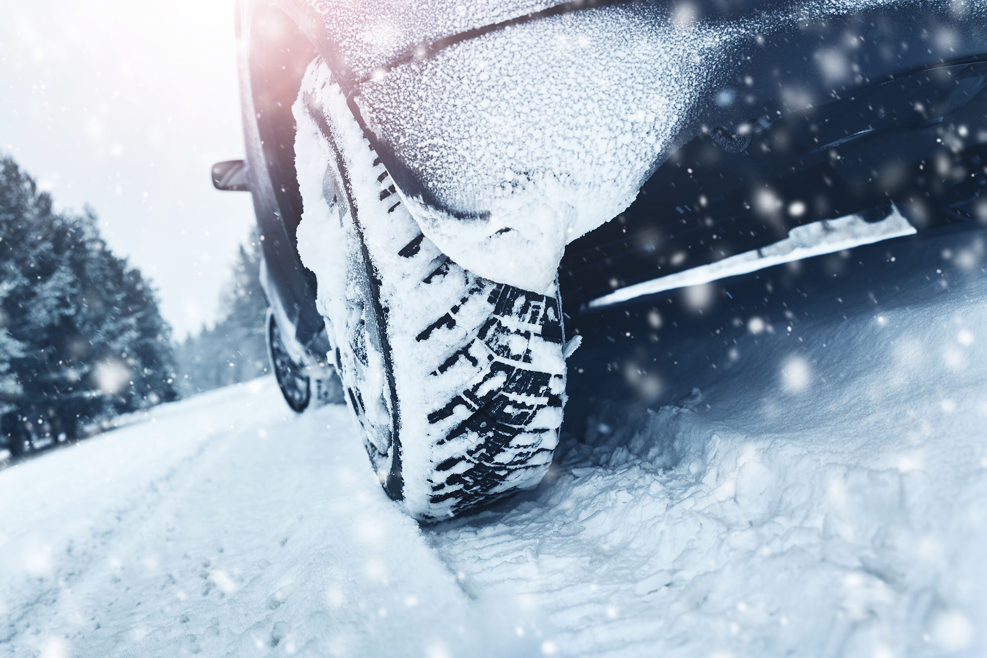 Close-up of a car's rear tire on a snowy road