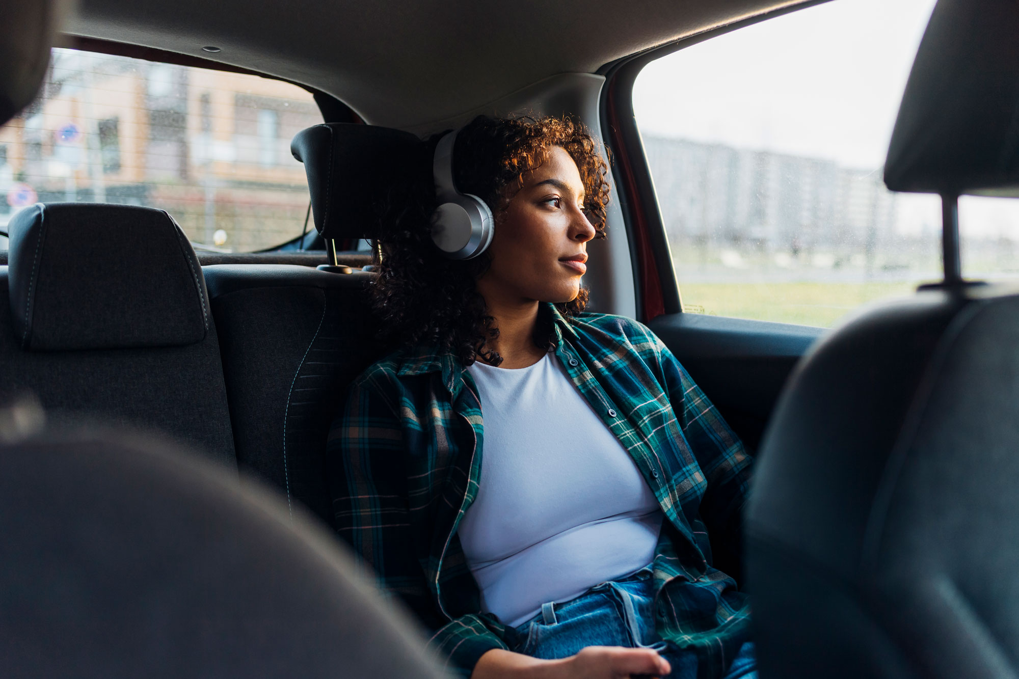 Person listening to headphones in car
