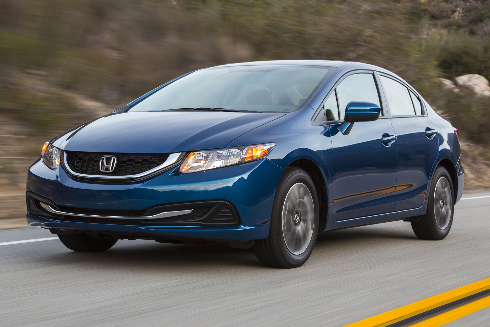 A blue 2014 Honda Civic driving on a highway