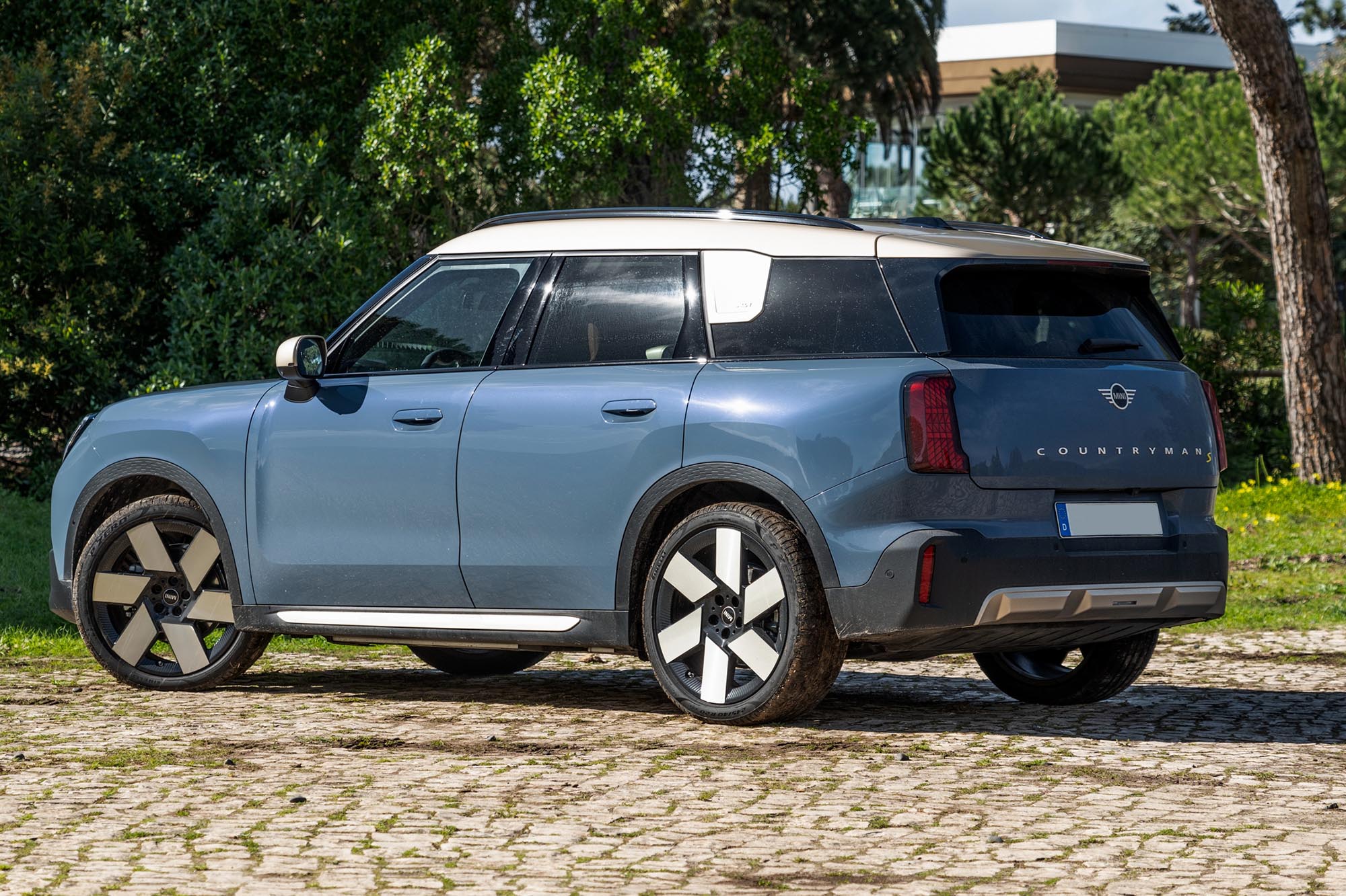 Left rear quarter view of a blue 2025 Mini Countryman SE with a white roof