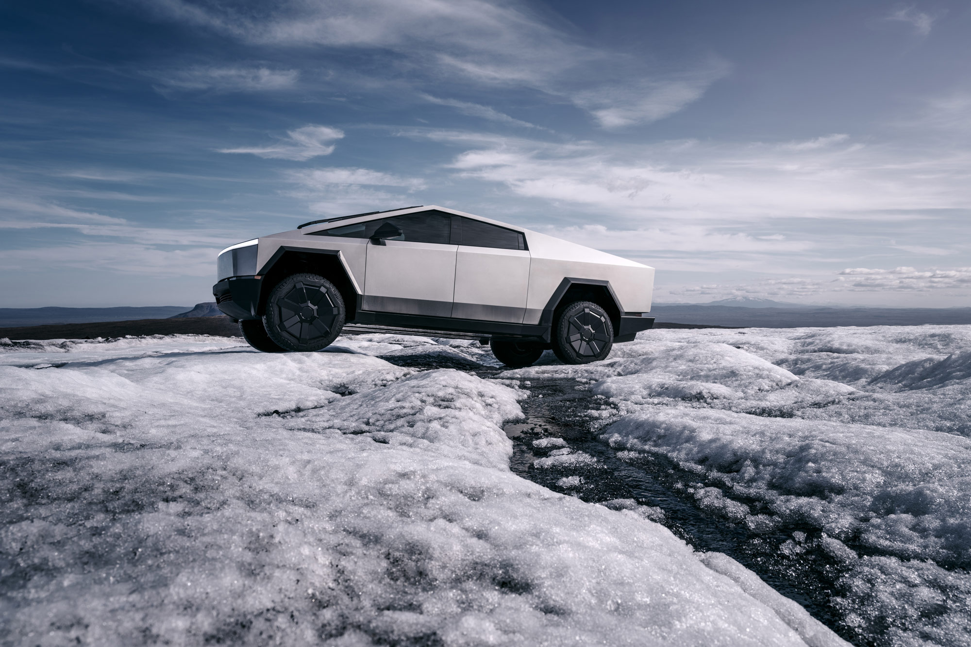 2024 Tesla Cybertruck drives across an icy plain.
