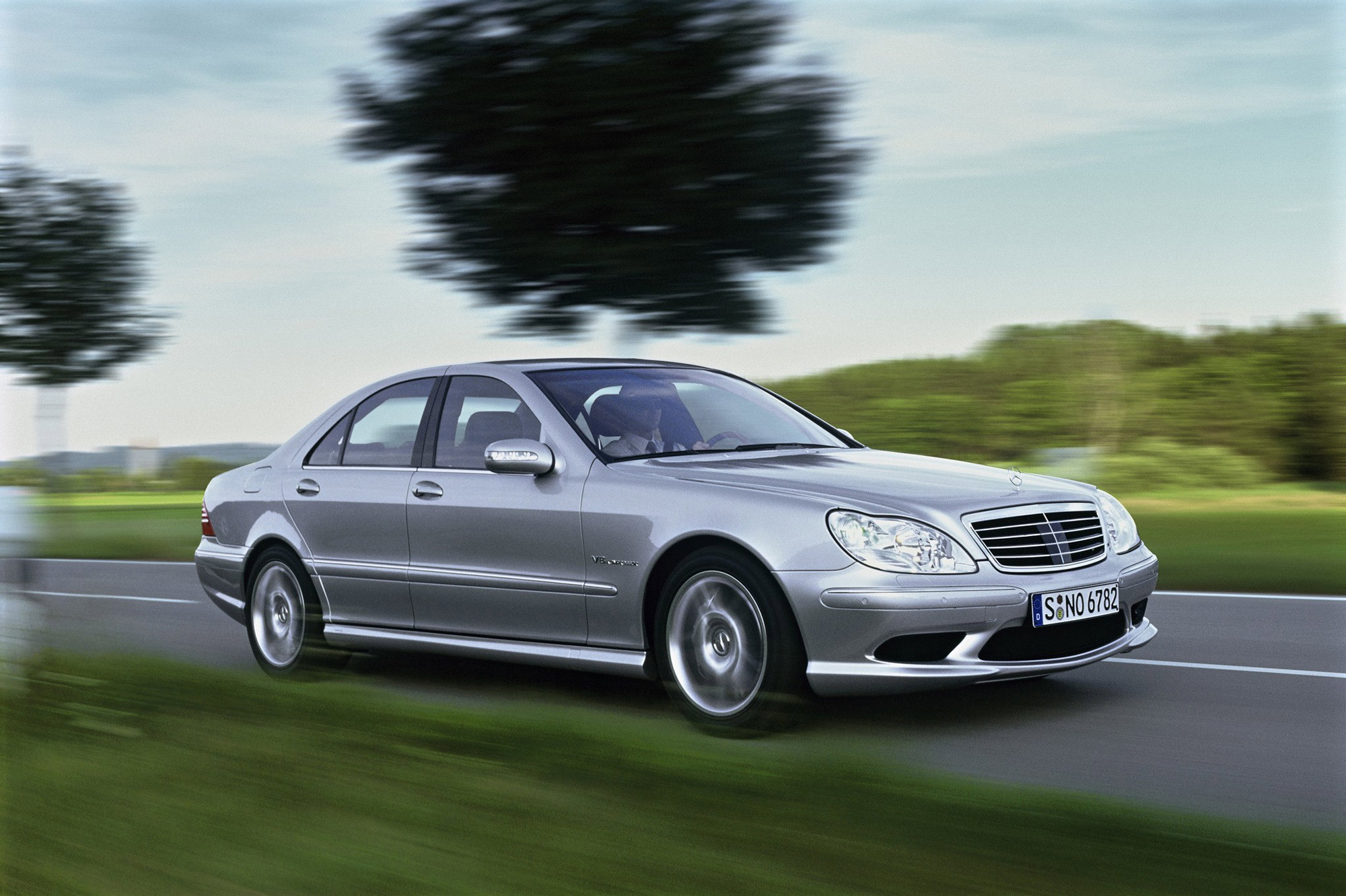 Silver 2004 Mercedes-Benz S-Class drives on country road.