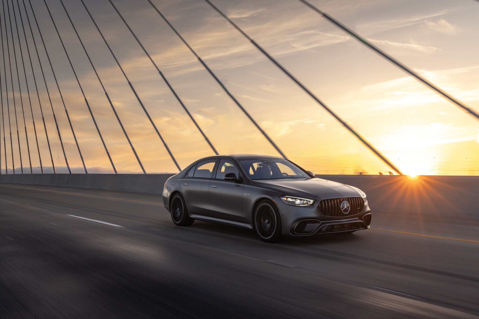 2024 Mercedes-Benz S-Class driving on bridge at sunset.