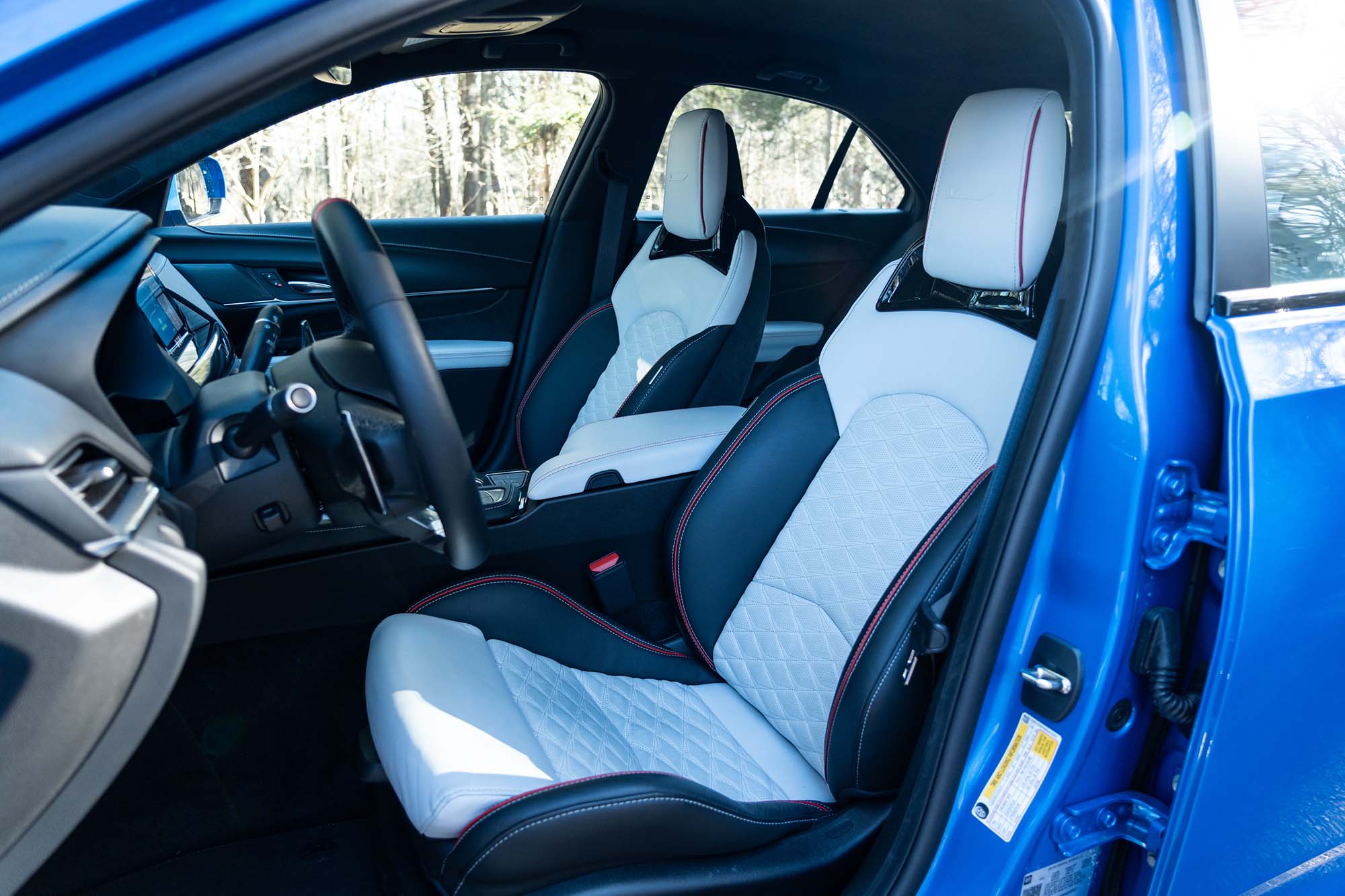 2024 Cadillac CT4-V Blackwing interior showing the front seats viewed through an open driver's door.