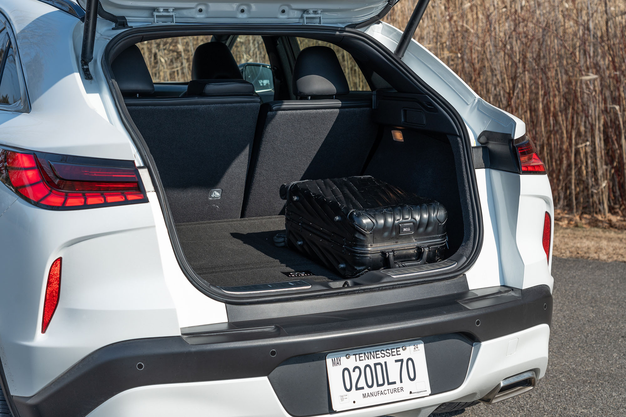The cargo area of a 2024 Infiniti QX55 holding a roll-on bag