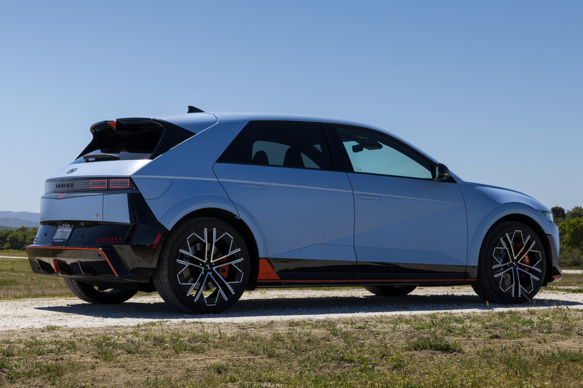 Light blue 2025 Hyundai Ioniq 5 N parked on gravel.