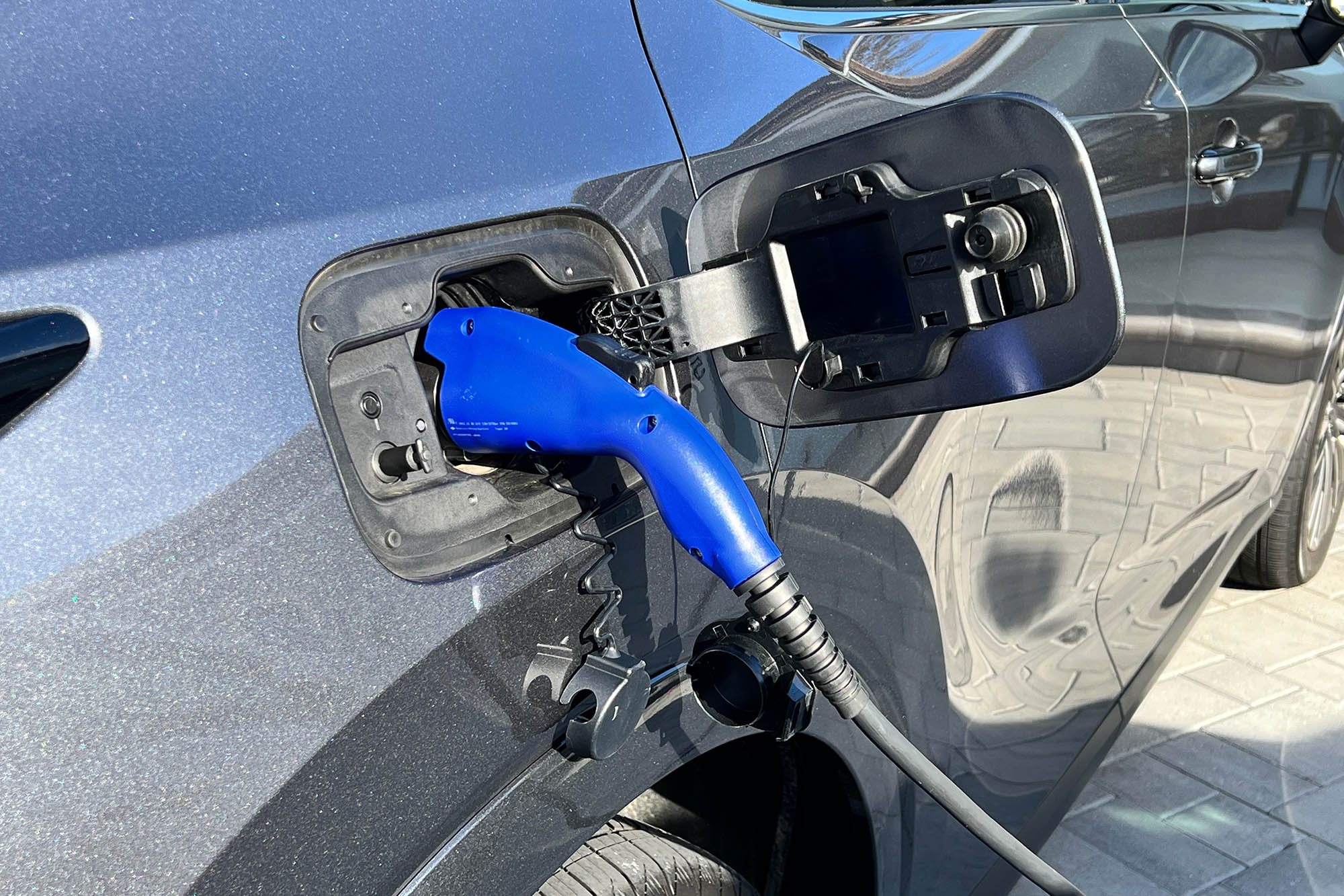View of a Lexus RX 450h+ plug-in hybrid's power port as it recharges.