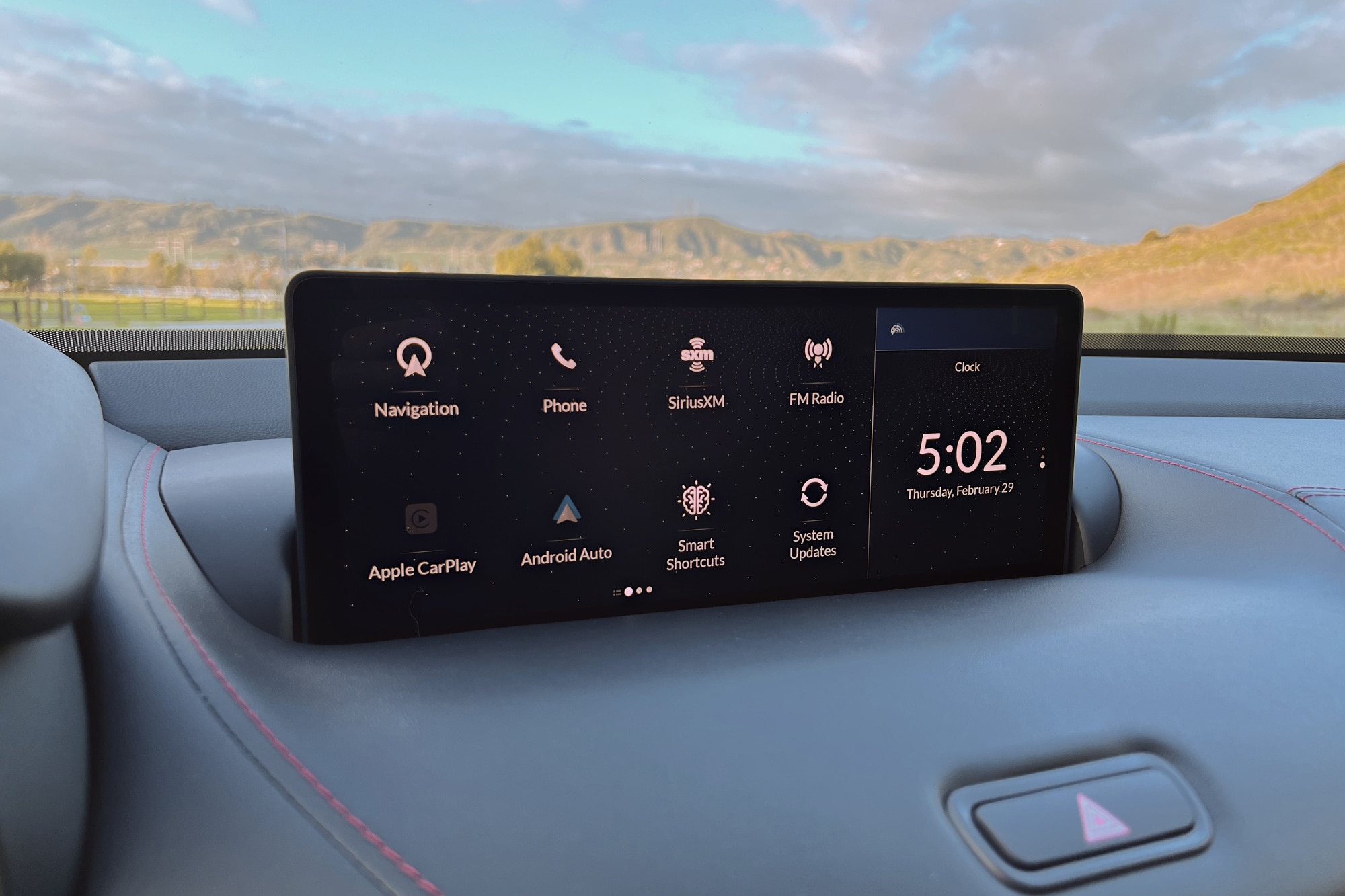 2024 Acura TLX Type S infotainment system with mountains and a partly cloudy sky