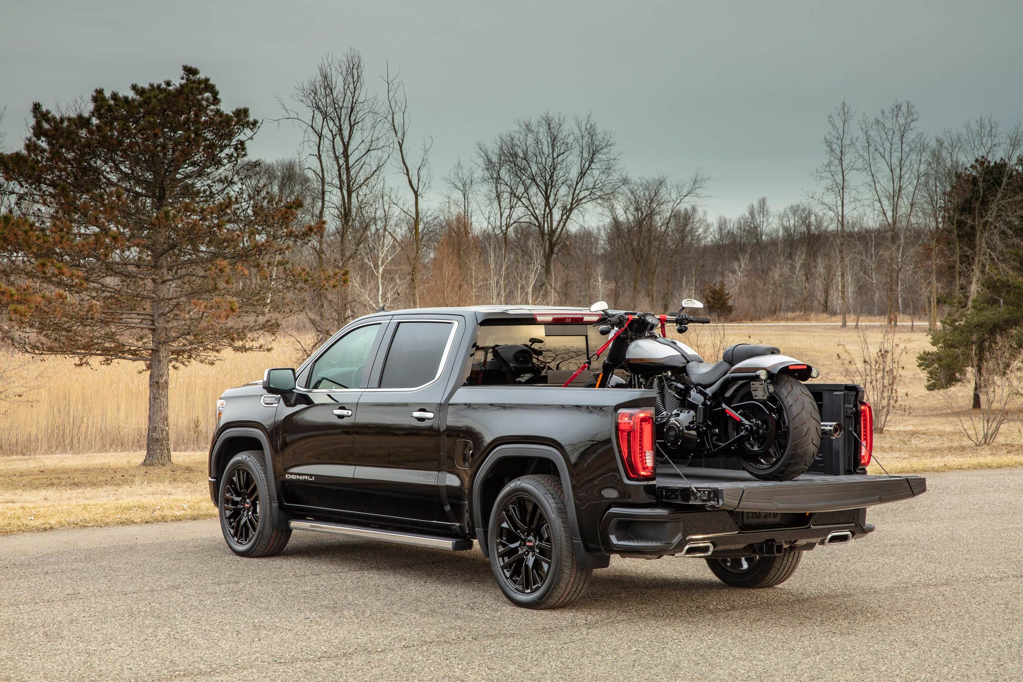 GMC Sierra 1500 with tailgate down and motorcycle in bed.