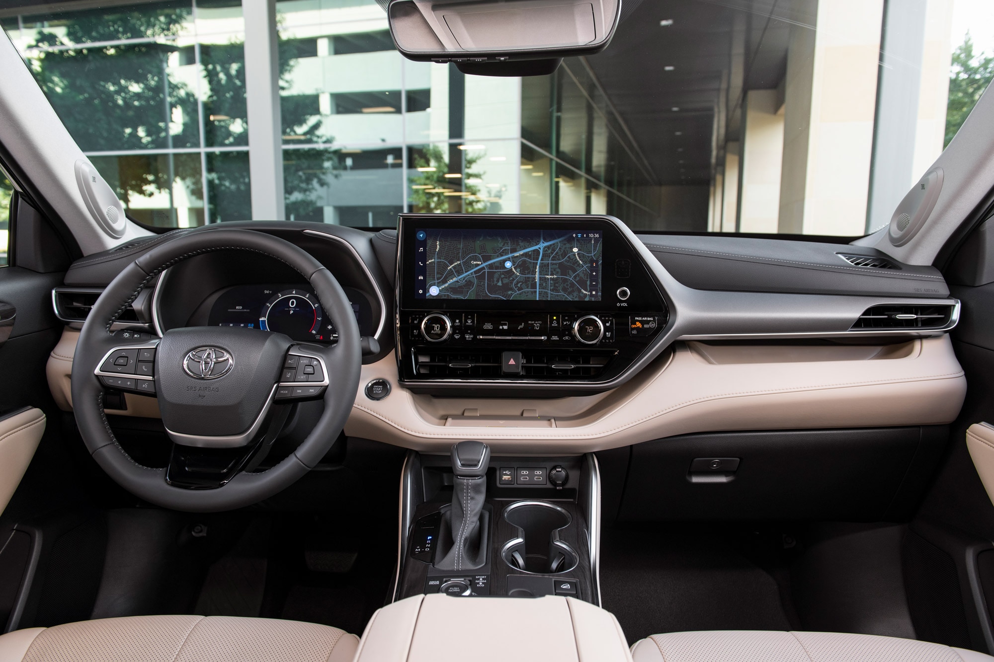 2024 Toyota Highlander interior, steering wheel, and infotainment screen.