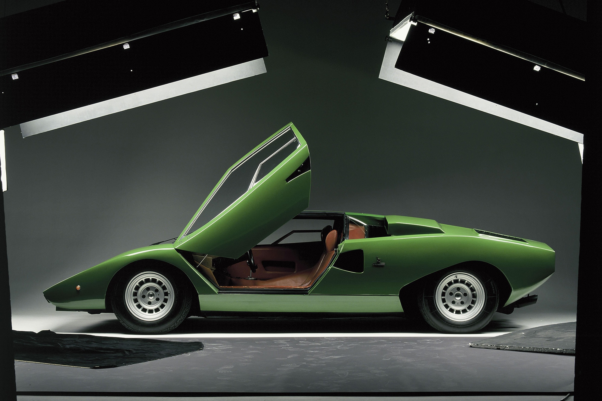 Green Lamborghini Countach with open scissor doors.