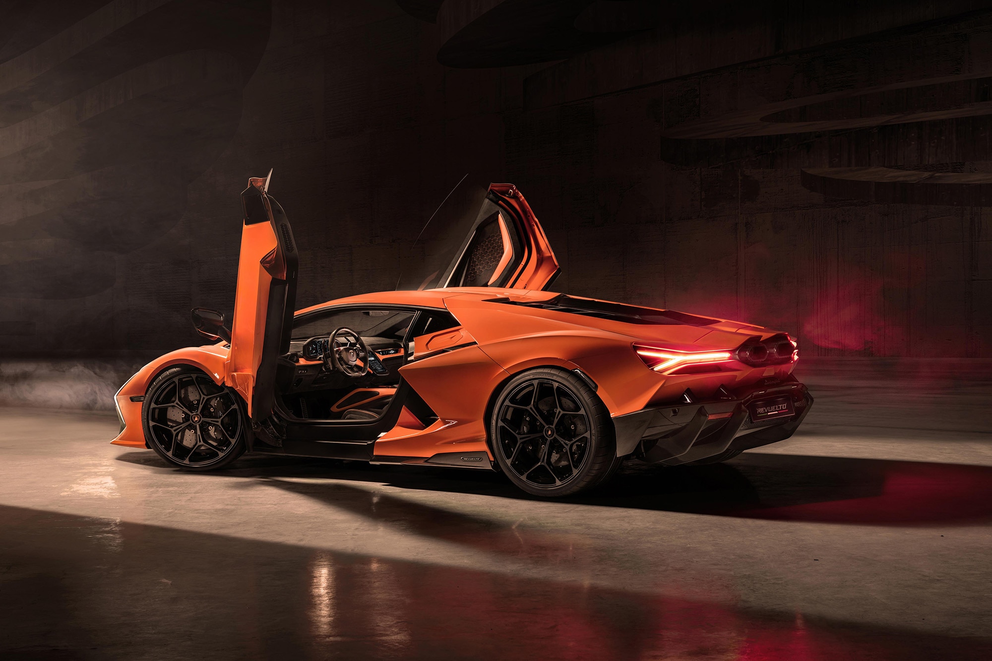 Orange Lamborghini Revuelto with open scissor doors.