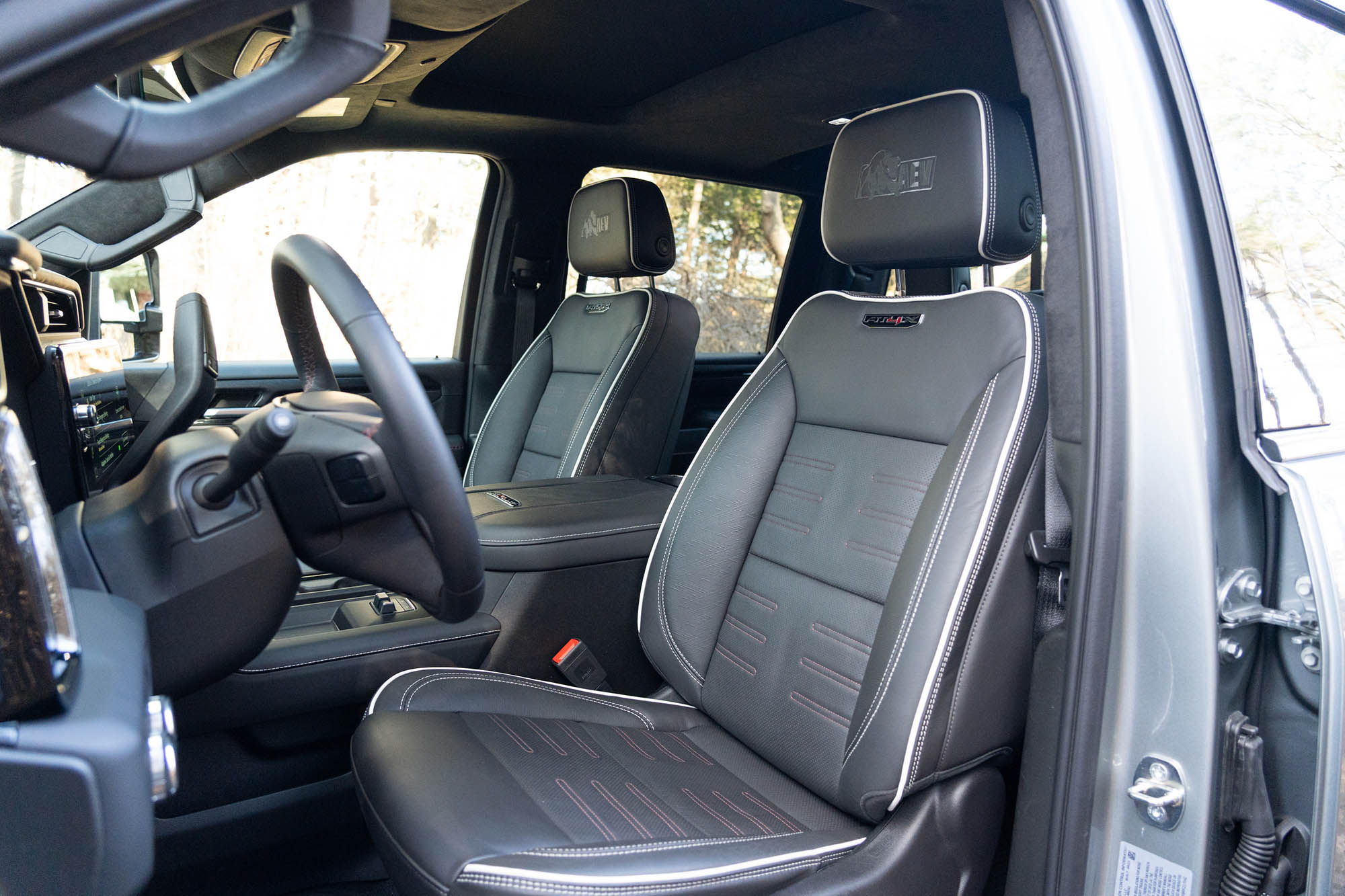 View of the 2024 GMC Sierra 2500HD AT4X AEV interior showing the front seats.