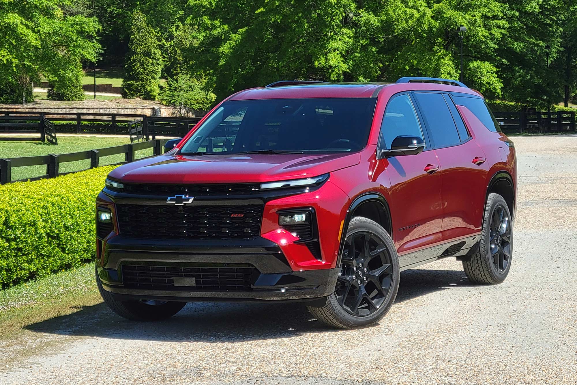 Red 2024 Chevrolet Traverse RS parked on a gravel road.