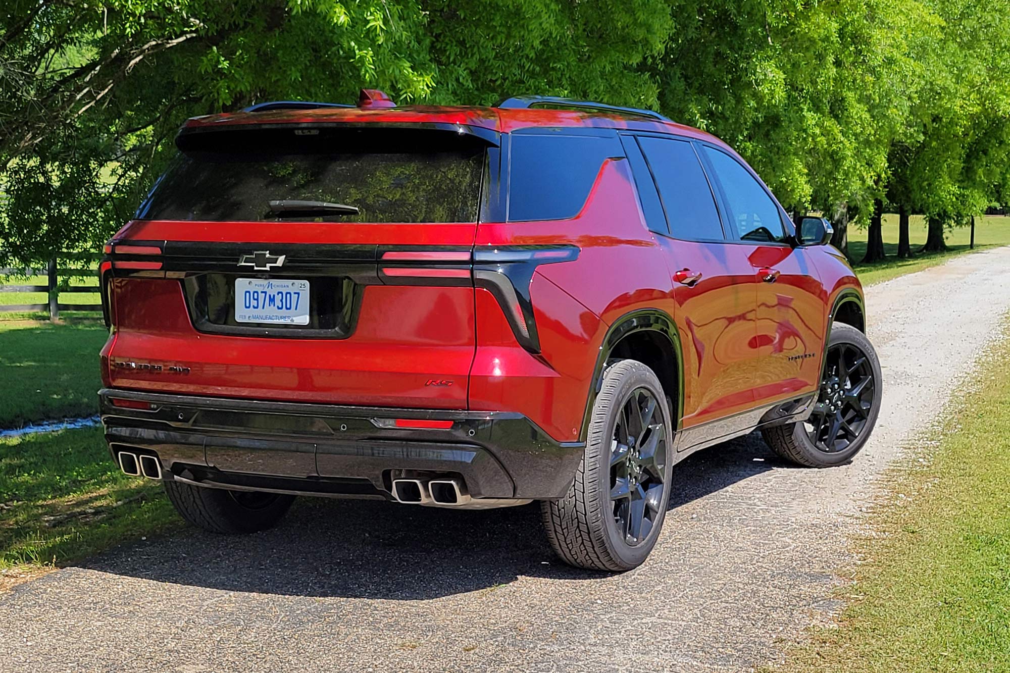 Red 2024 Chevrolet Traverse RS parked on a single-lane road.