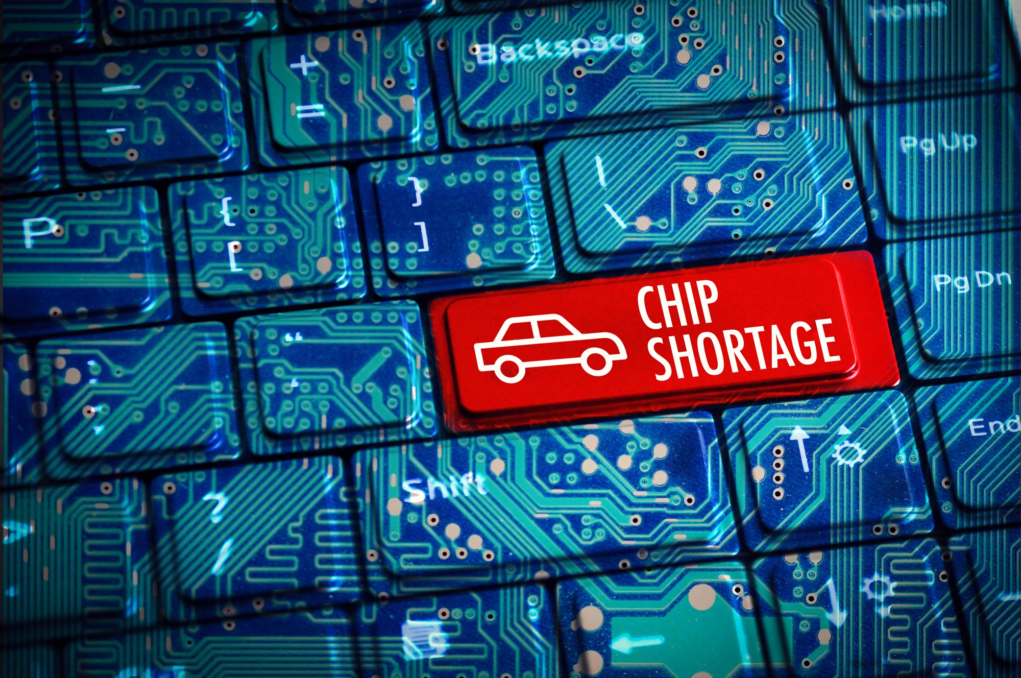 Red semiconductor chip shortage sign illustrated over a motherboard on a keyboard