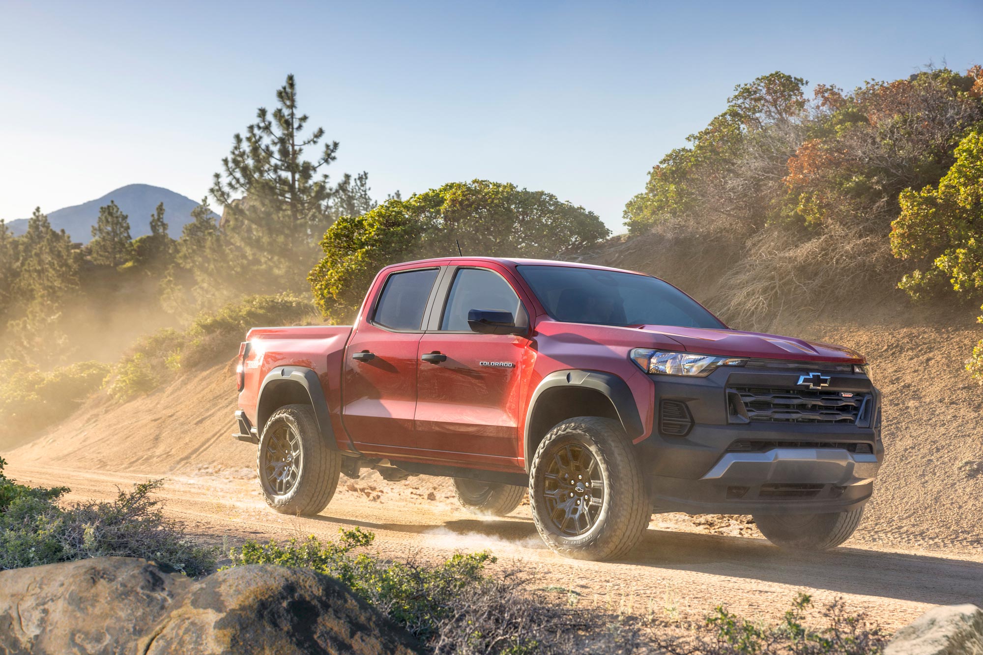 2023 Chevrolet Colorado Trail Boss driving down dirt trail.