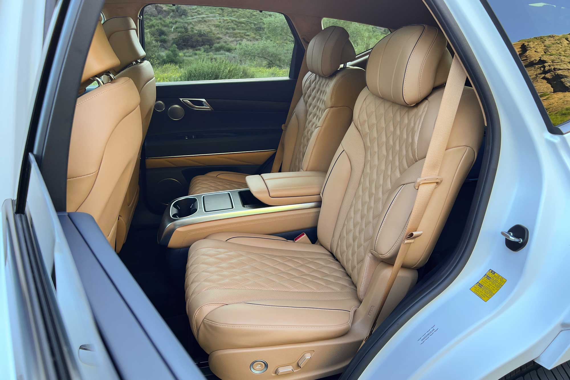 View of the 2024 Genesis GV80 3.5T Prestige Signature interior showing the individual second-row captain's chairs divided by a center console.