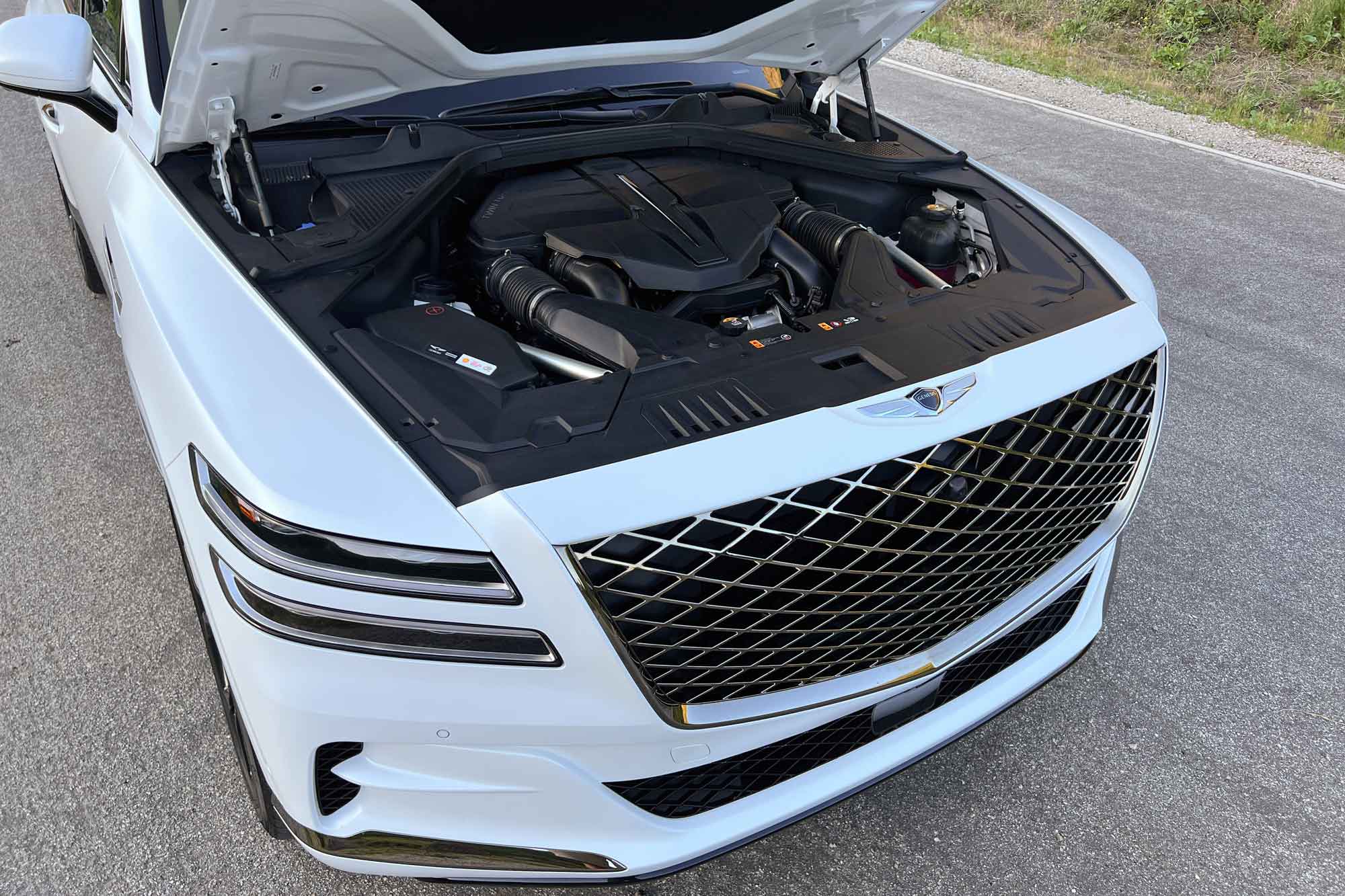 View of the 2024 Genesis GV80 3.5T Prestige Signature model's twin-turbocharged 3.5-liter V6 engine.