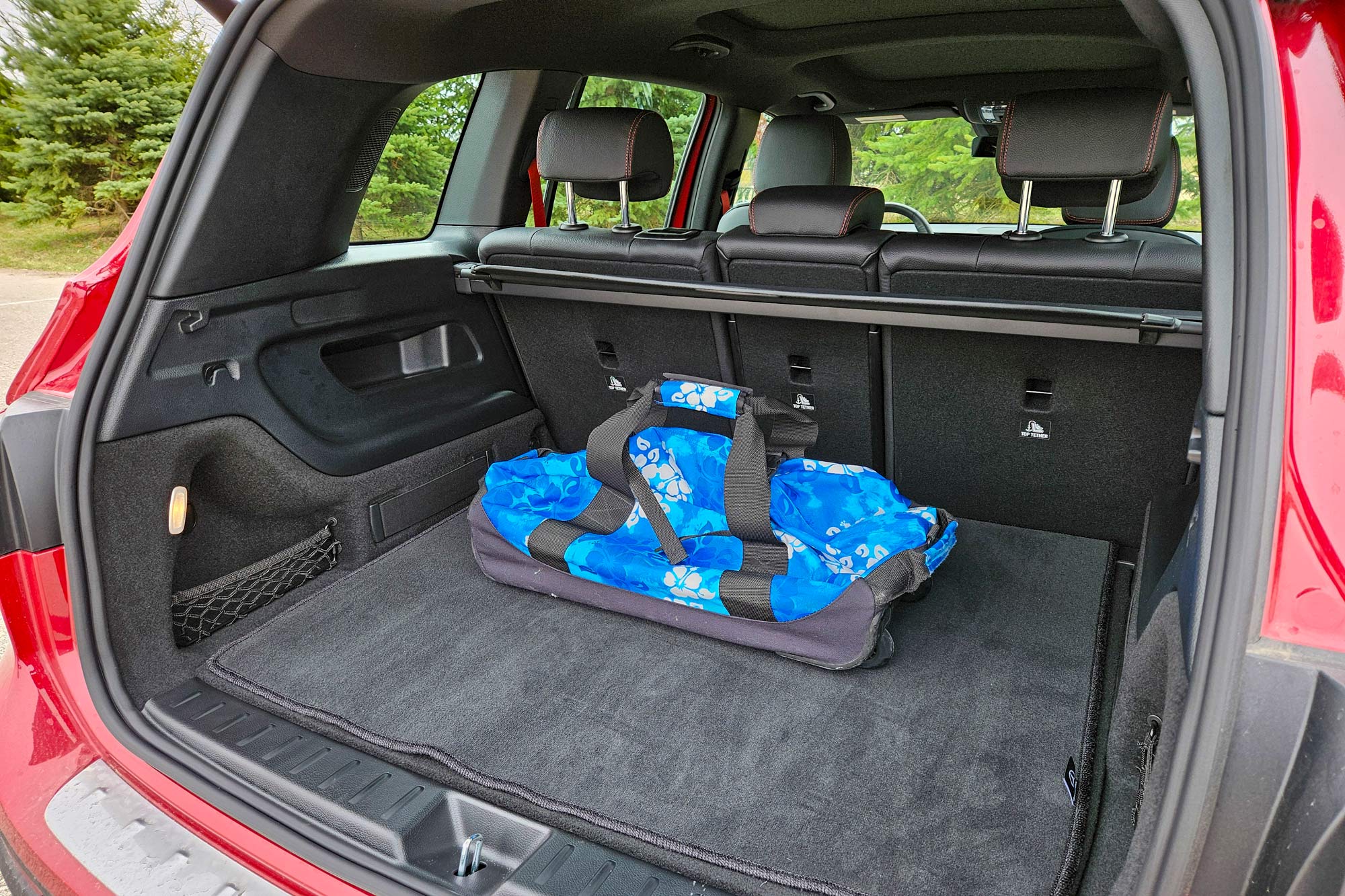 Red 2024 Mercedes-AMG GLB 35 cargo trunk with blue duffel bag