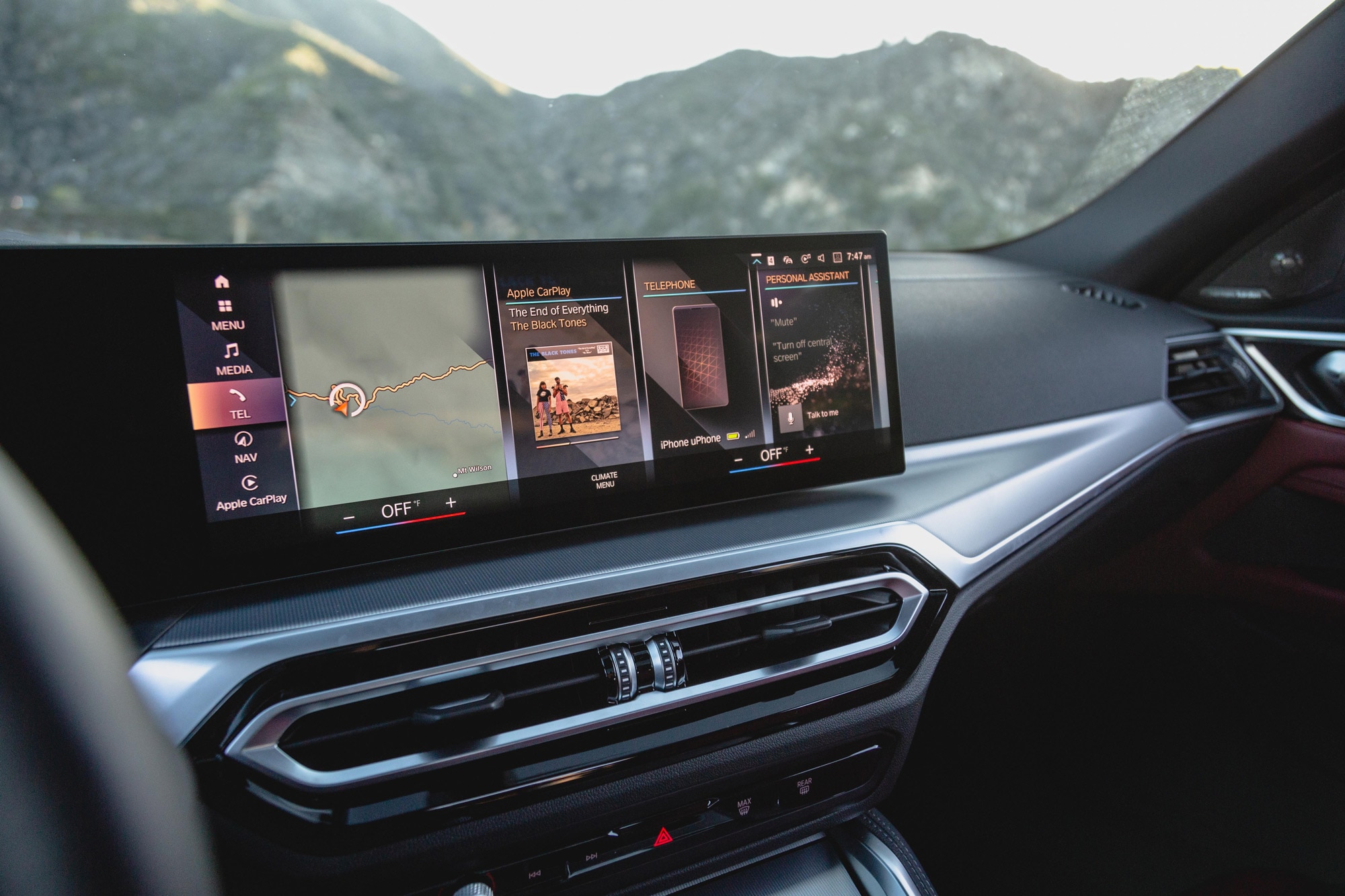 BMW i4 M50 infotainment screen with mountain peaks in the background