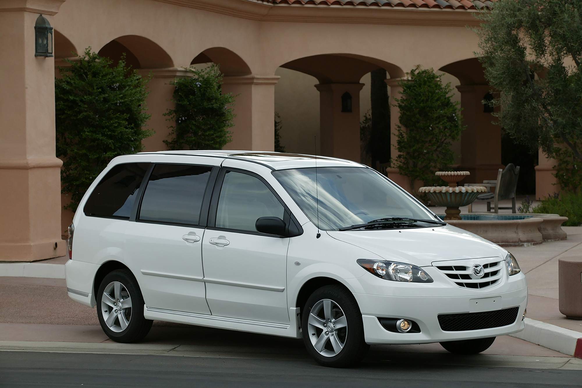 2005 Mazda MPV in white parked in front of a building with columns.