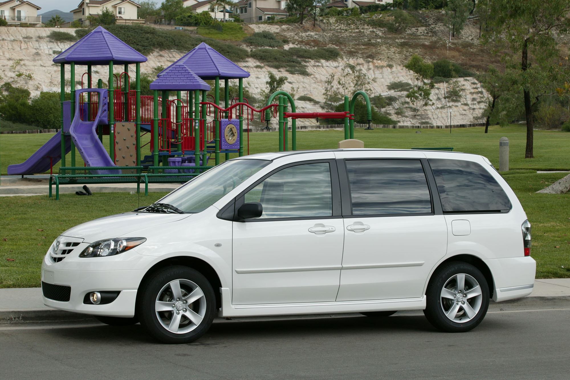 2005 Mazda MPV in white parked in front of a playground.
