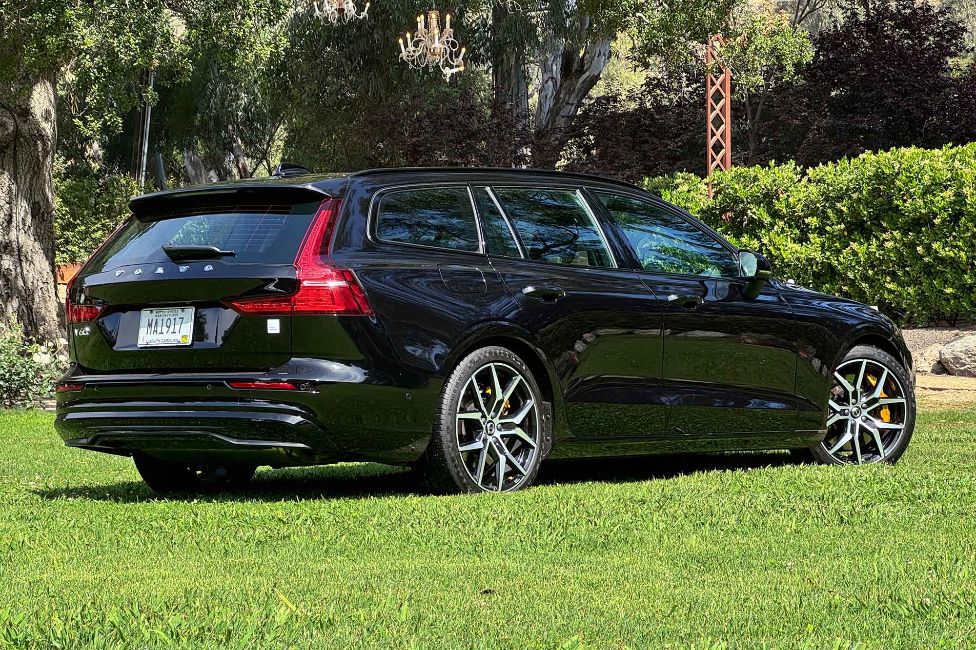 Right rear quarter view of a black 2024 Volvo V60 Recharge Polestar Engineered parked on grass.
