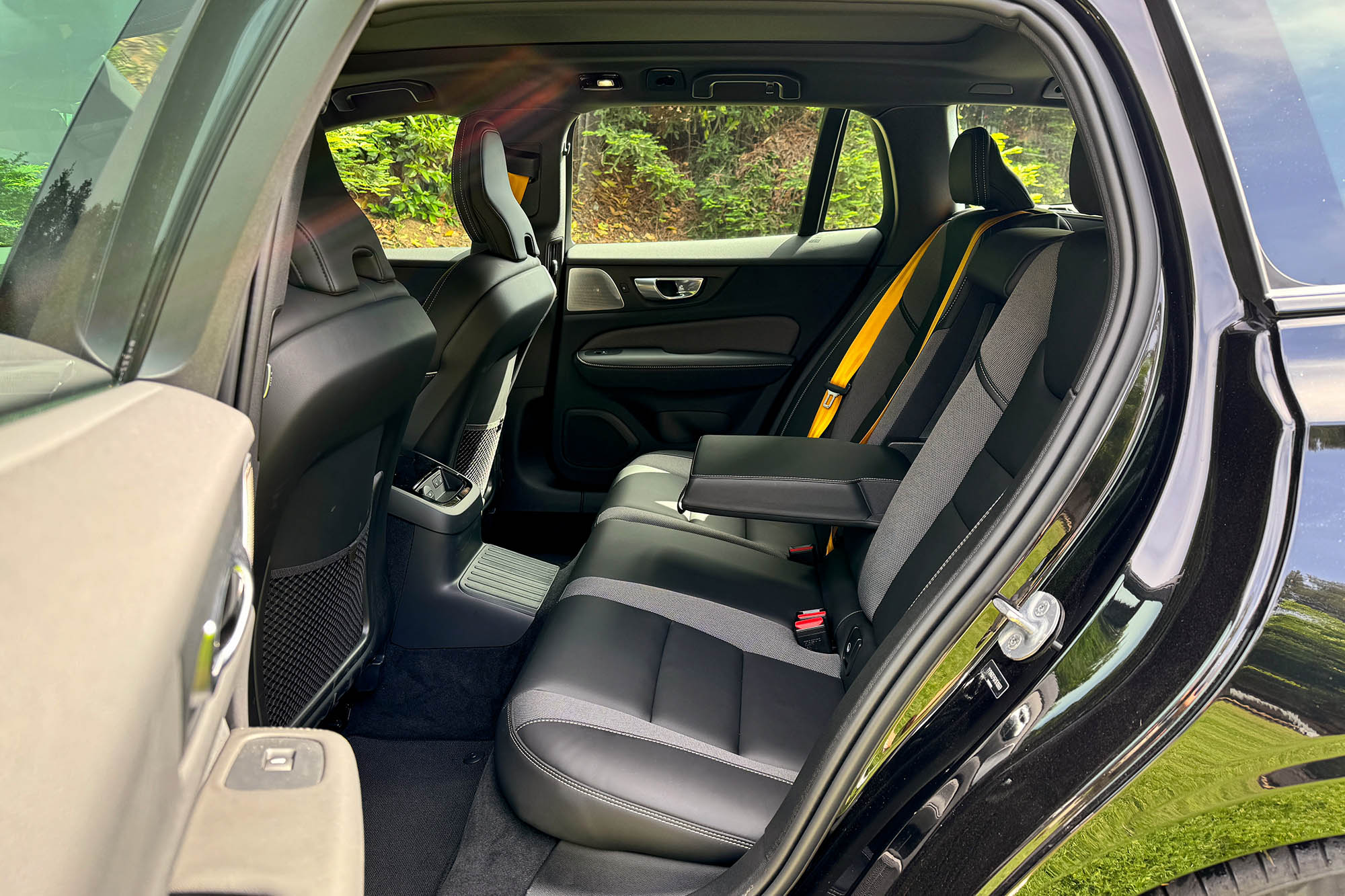View of the 2024 Volvo V60 Recharge Polestar Engineered interior showing the back seats and gold seatbelts.