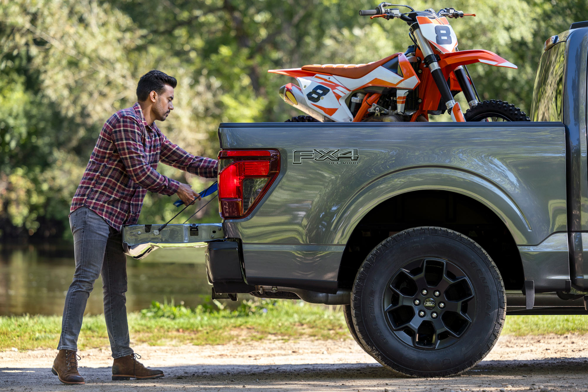Person secures motorcycles in bed of gray Ford F-150 FX4.