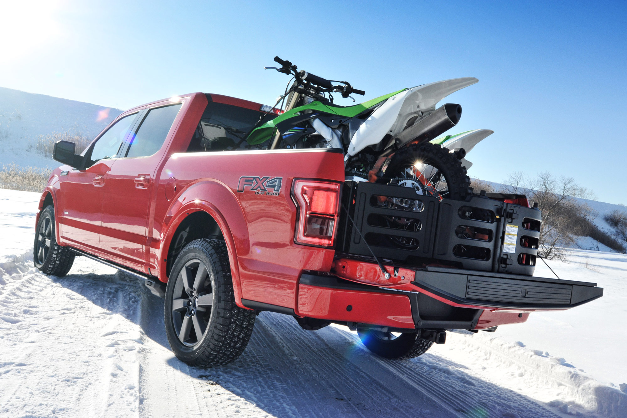 Pair of motorcycles in bed of red Ford F-150 FX4 on snow