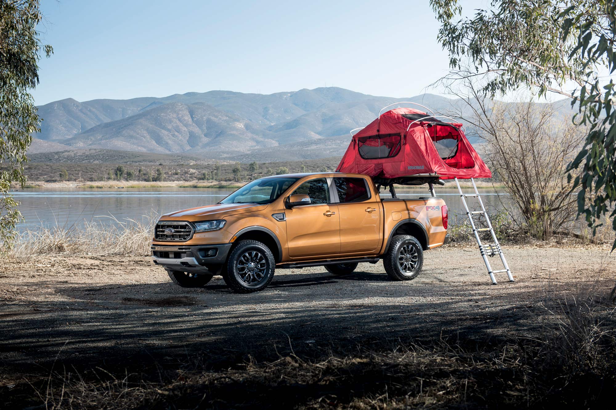 Ford Ranger FX4 with pop-up camper deployed parked near a lake.
