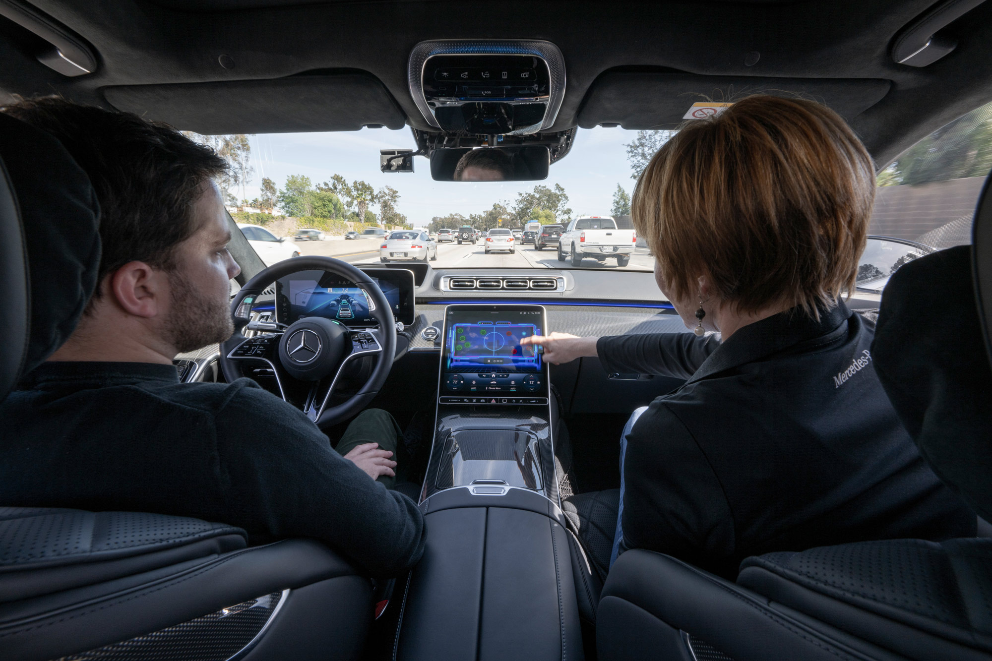 Two people demonstrate how Level 3 autonomous driving works in a Mercedes-Benz.