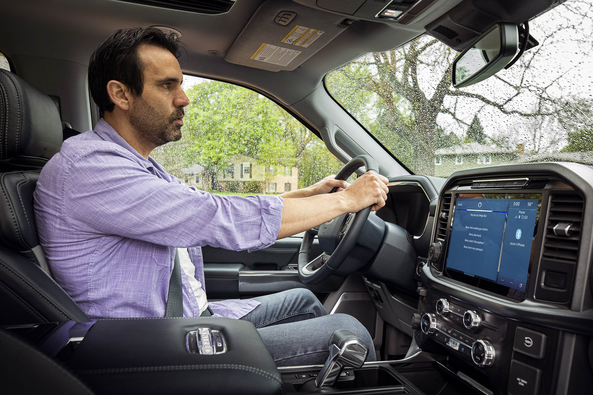 Person drives Ford vehicle with Amazon Alexa Built-in on the infotainment screen.