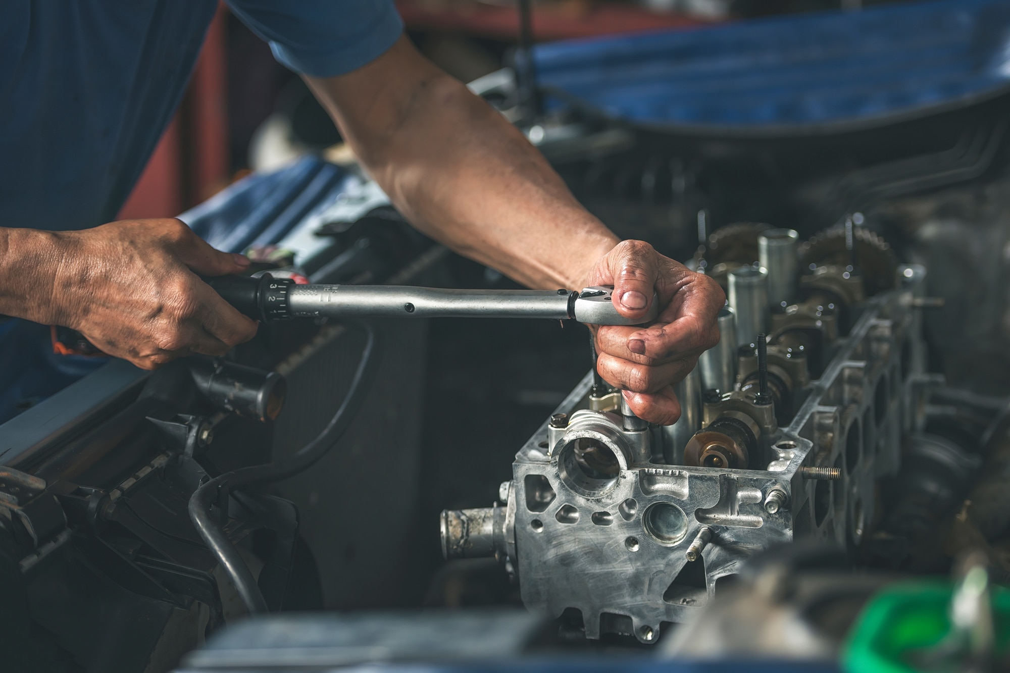 Person uses torque wrench to tighten engine bolts.