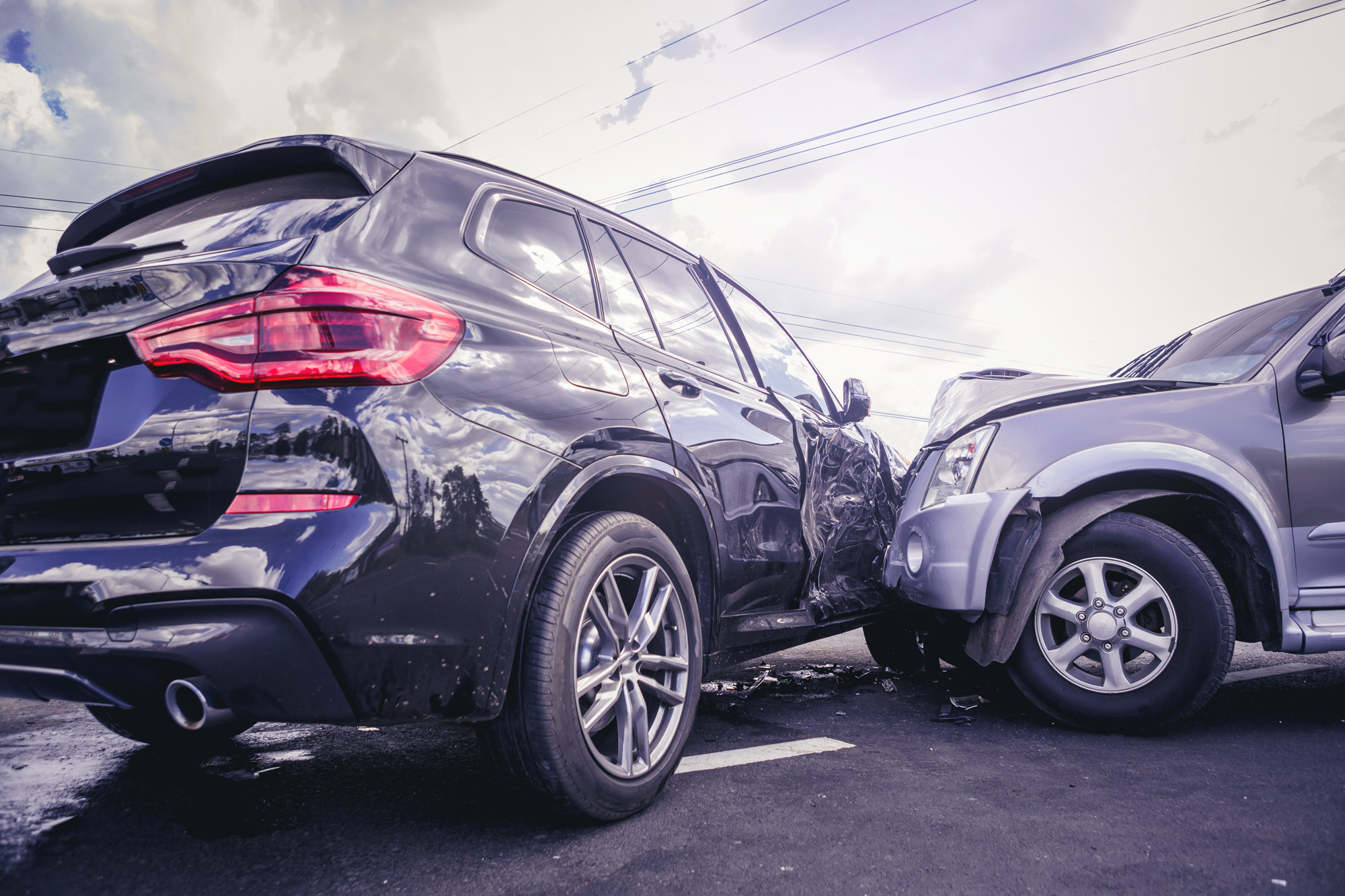 Two SUVs sit on a roadway after a crash.