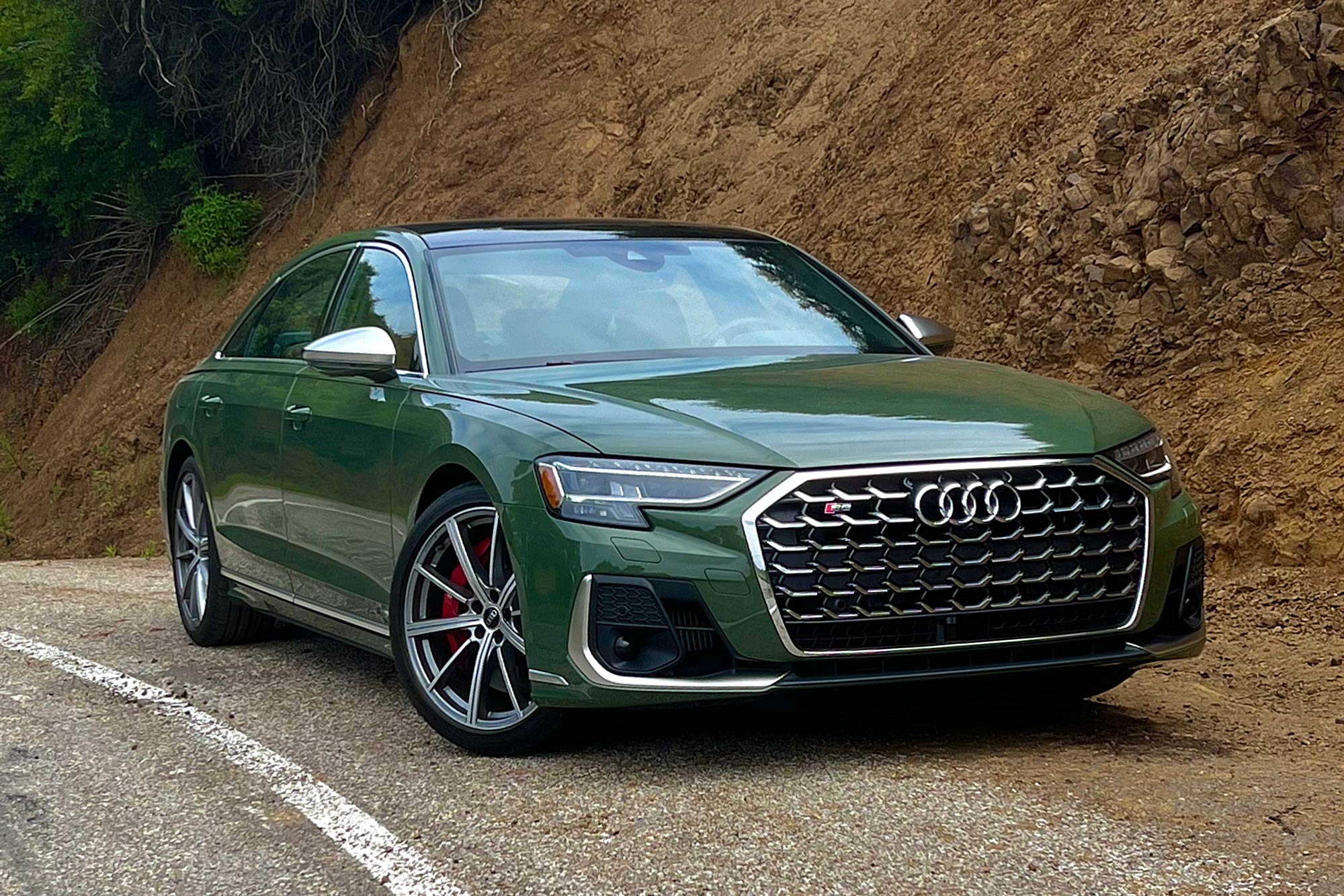 District Green 2024 Audi S8 parked on the side of a road.